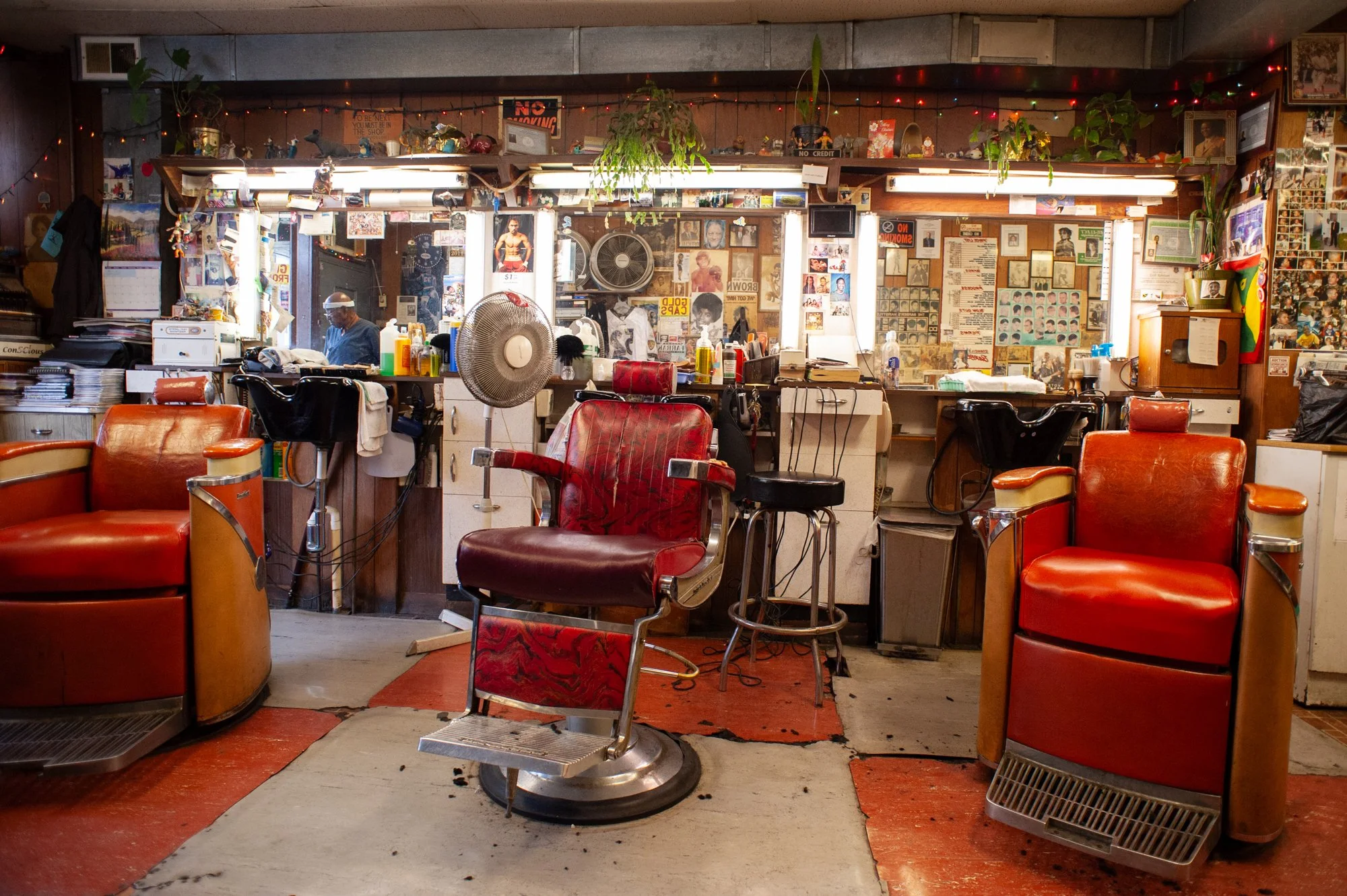 Interior of a traditional barbershop with red vintage barber chairs and mirrors