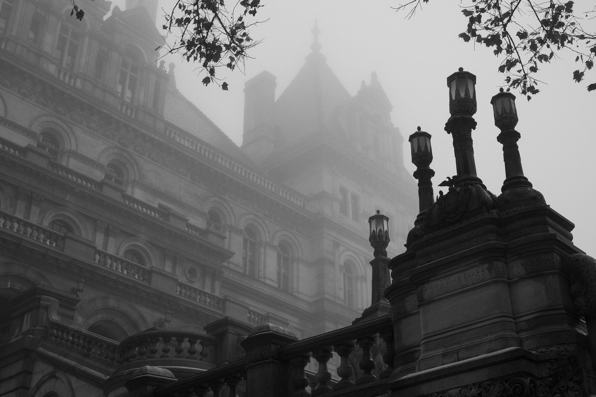 Black and white photograph of decorative balustrades and lampposts at the New York State Capitol in fog