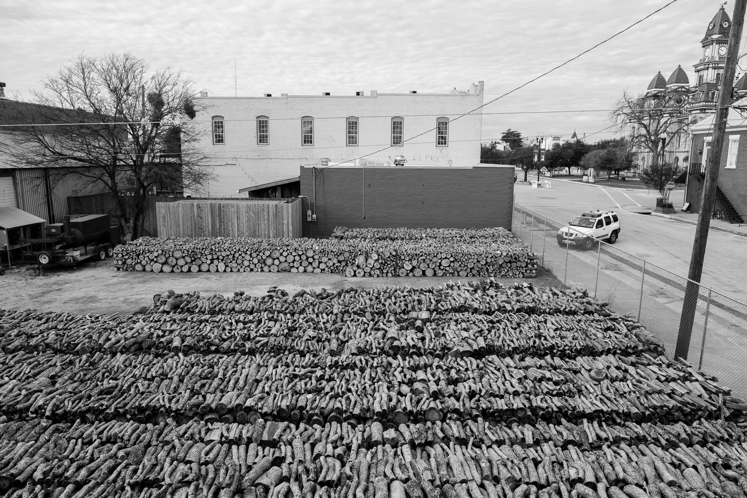 Stacks of split post oak firewood behind Smitty's Market in Lockhart, Texas