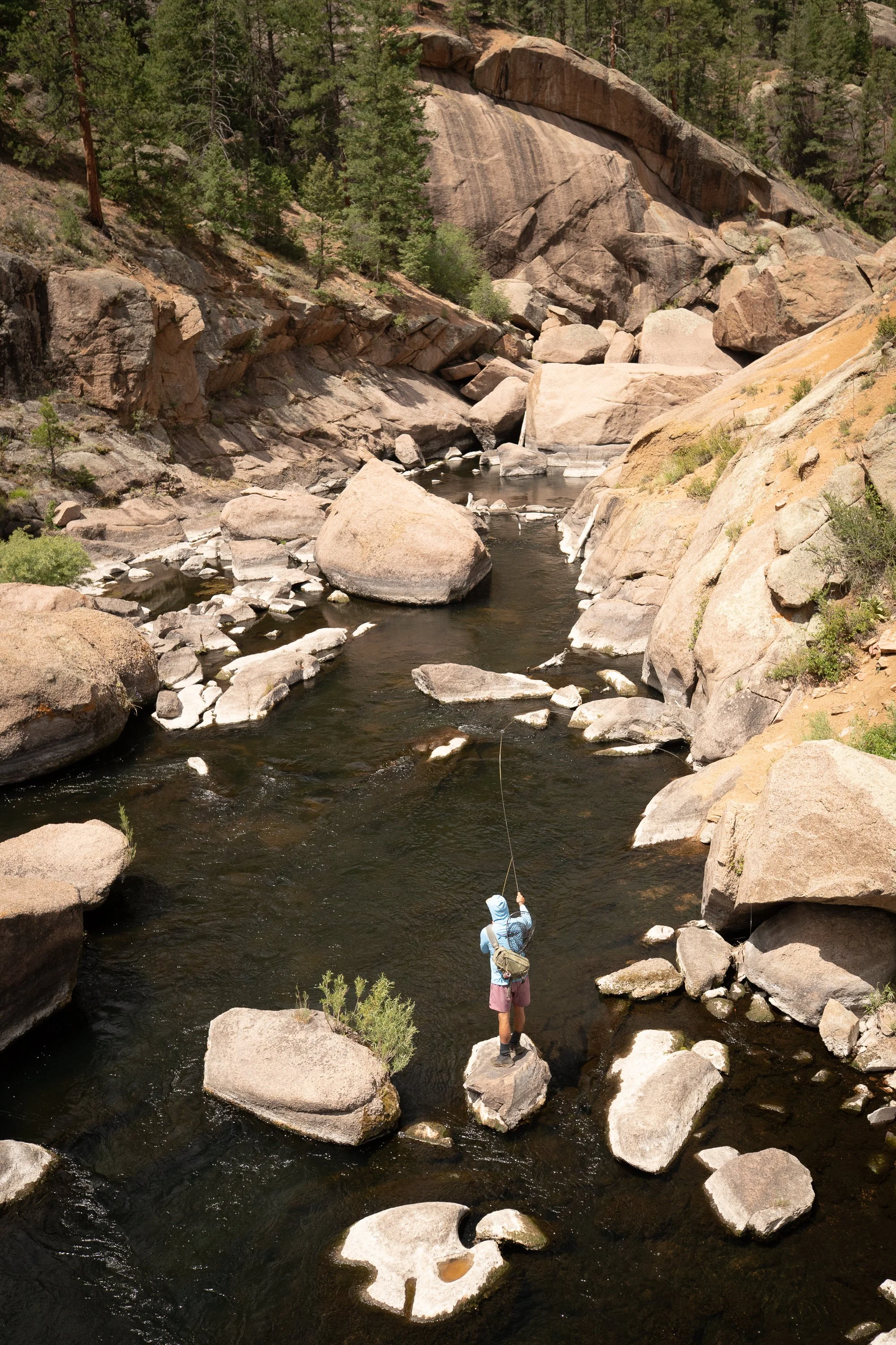Photograph of a fly fisherman in Cheesman Canyon surrounded by boulders and granite walls