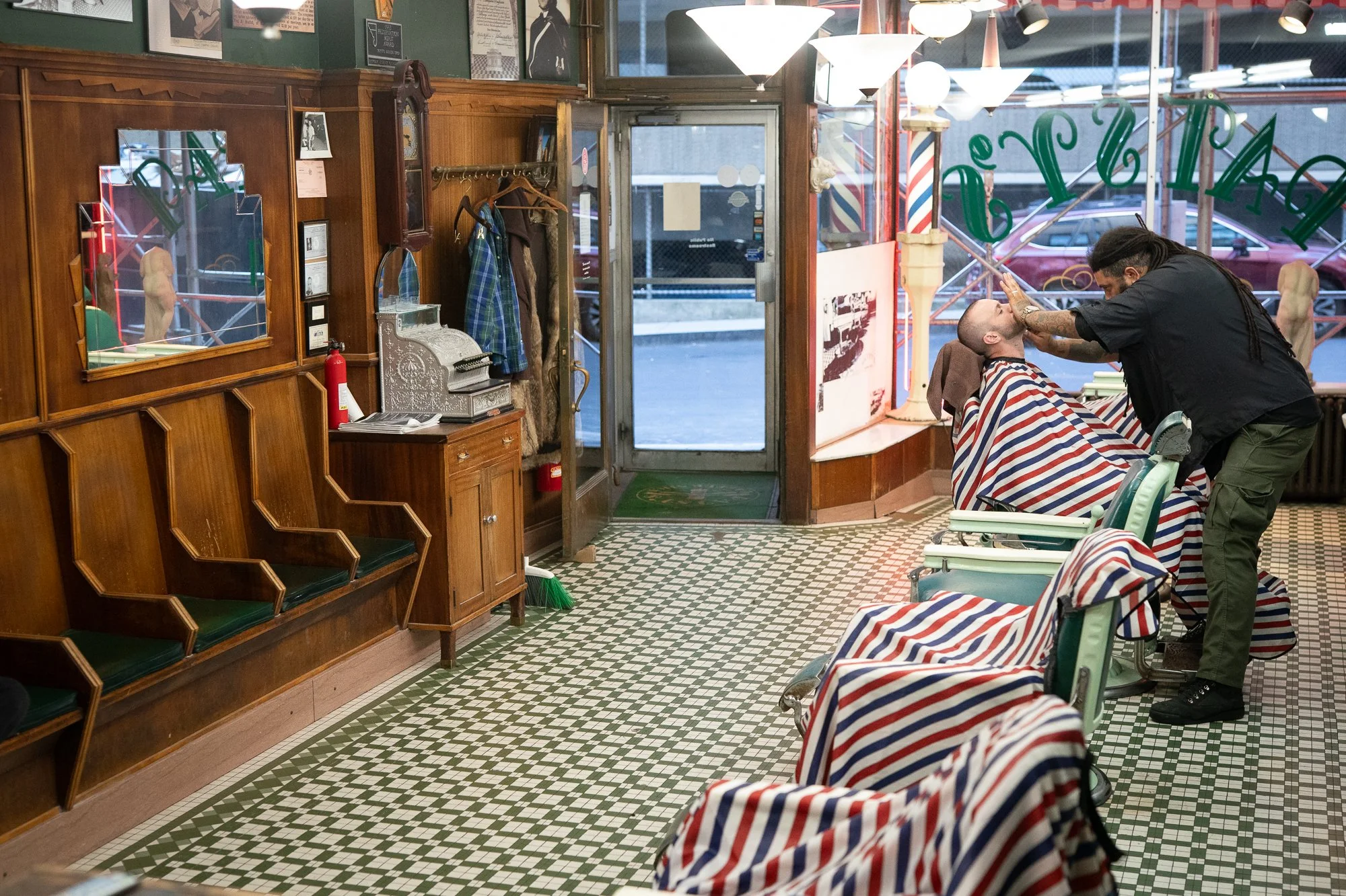 Barber giving a shave inside the classic interior of Patsy’s Barbershop in Albany New York