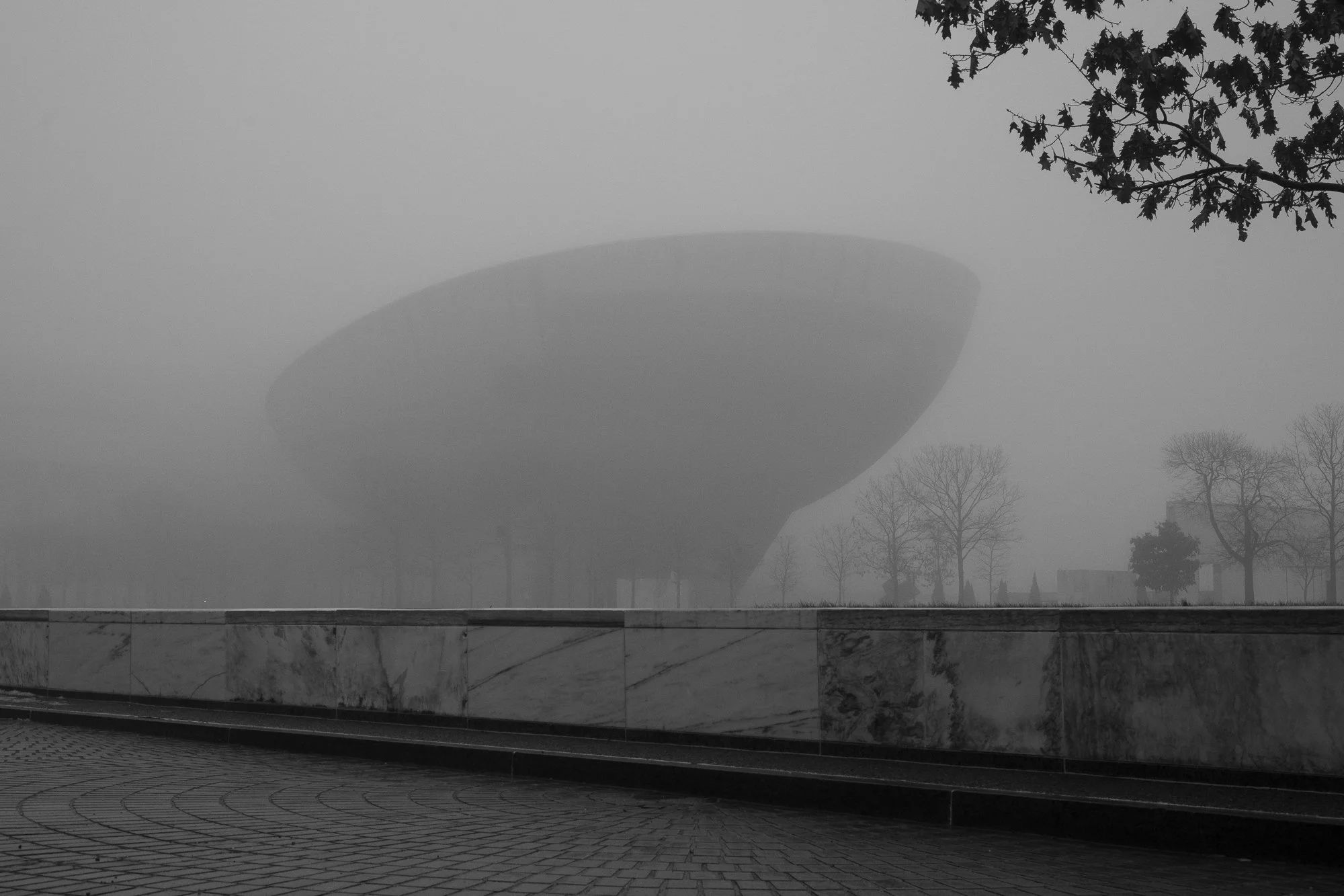 Black and white photograph of The Egg performing arts center partially obscured by fog in Albany