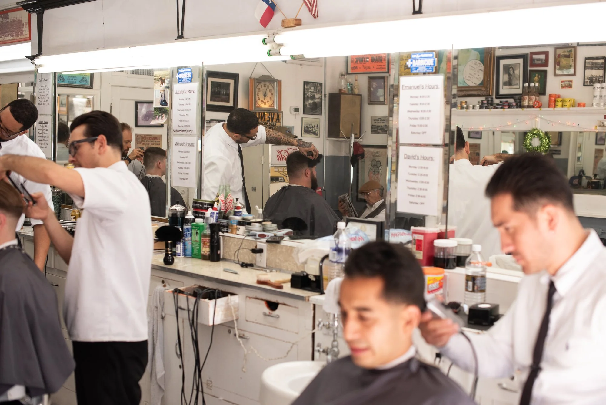 Barbers work along a row of chairs inside Avenue Barbershop in Austin, Texas