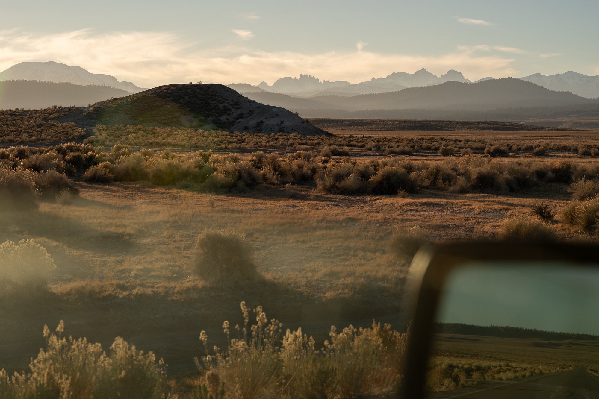 Eastern California desert landscape with brush, distant mountains, and a roadside view