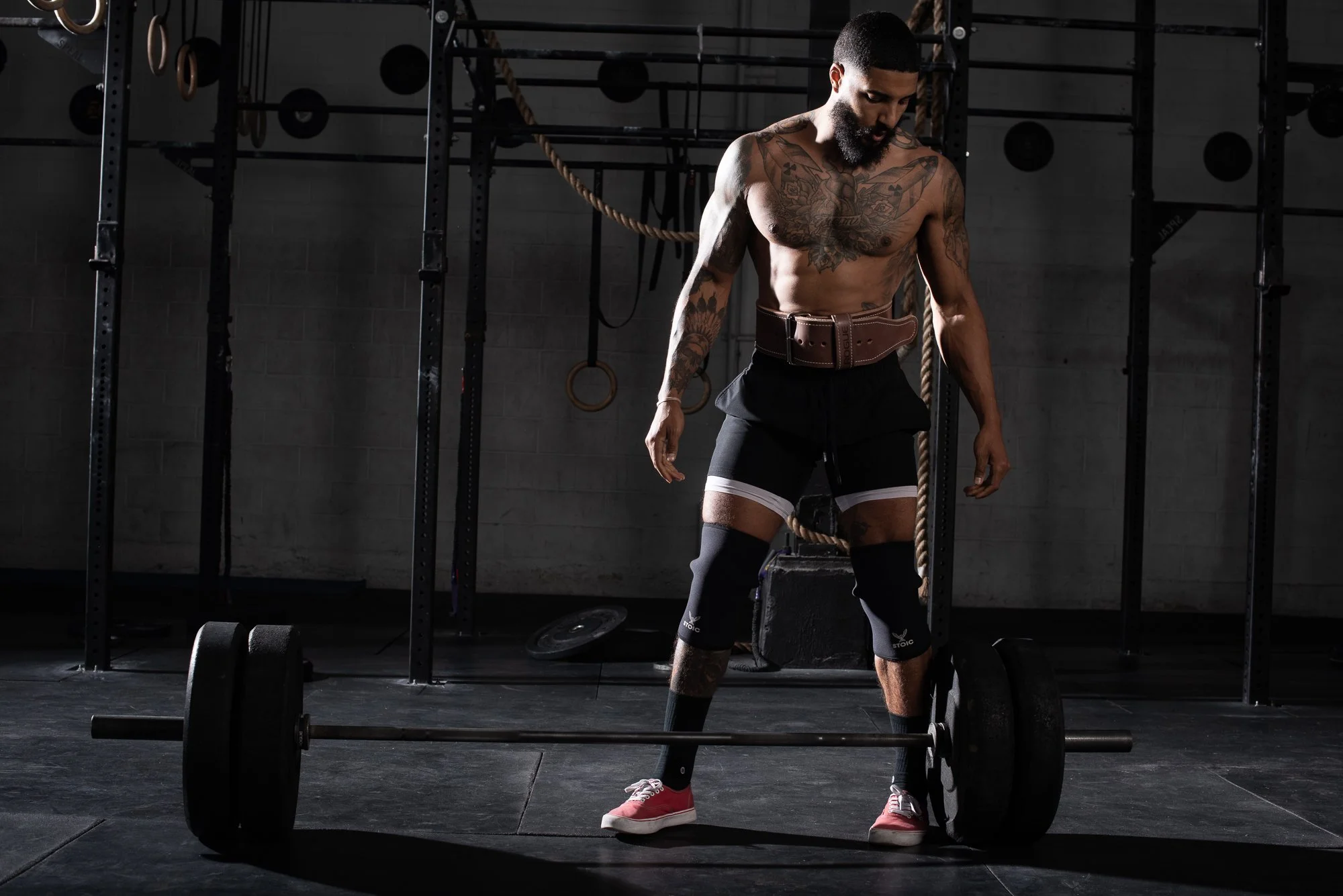 Athlete stands over a loaded barbell preparing for a deadlift in a Colorado gym