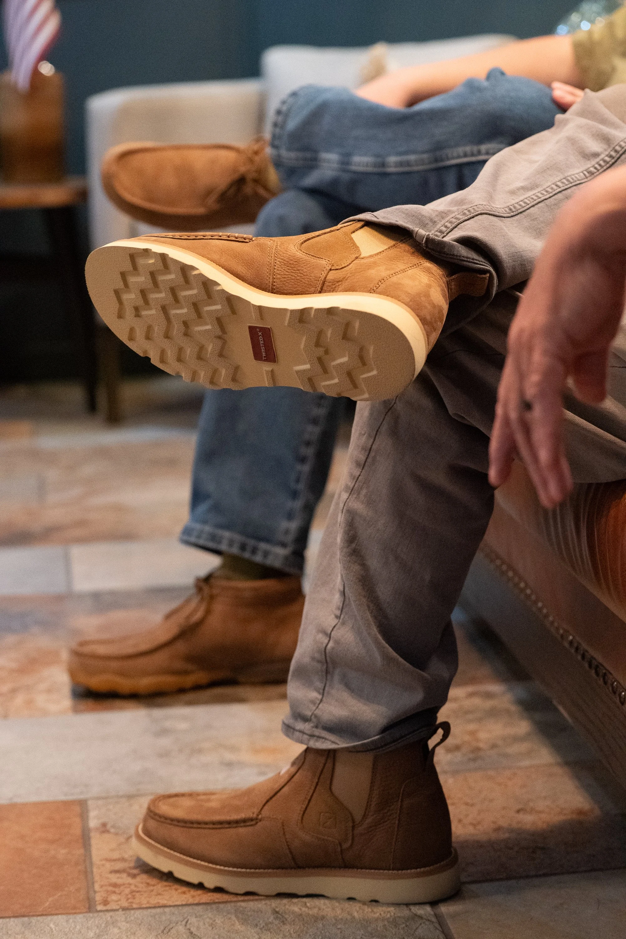 Close detail of Twisted X boots worn by people seated inside a VFW hall