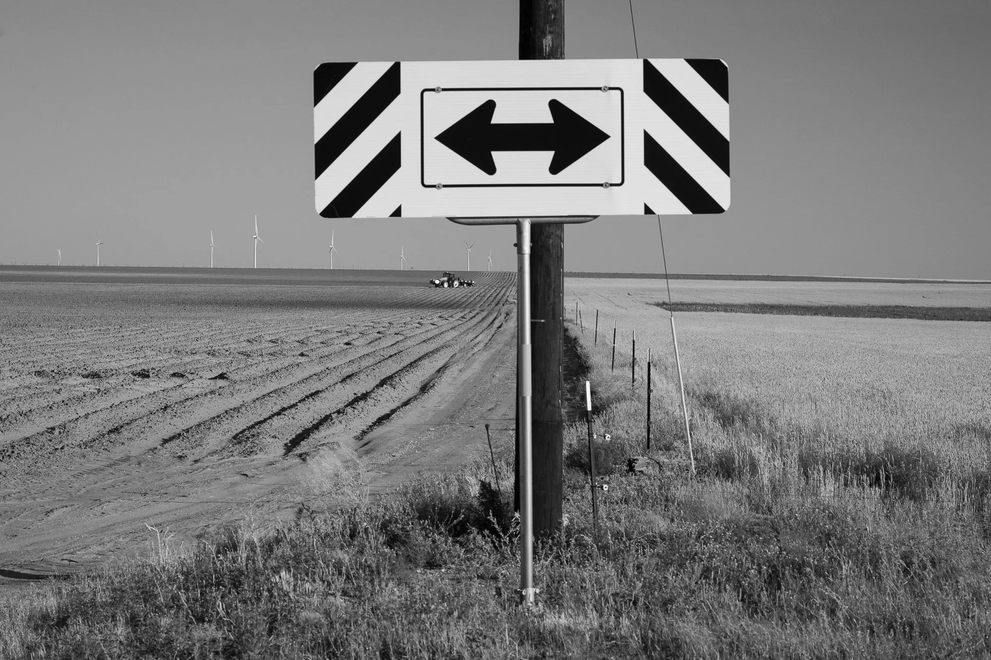 Black and white photograph of a rural directional road sign on the Llano Estacado