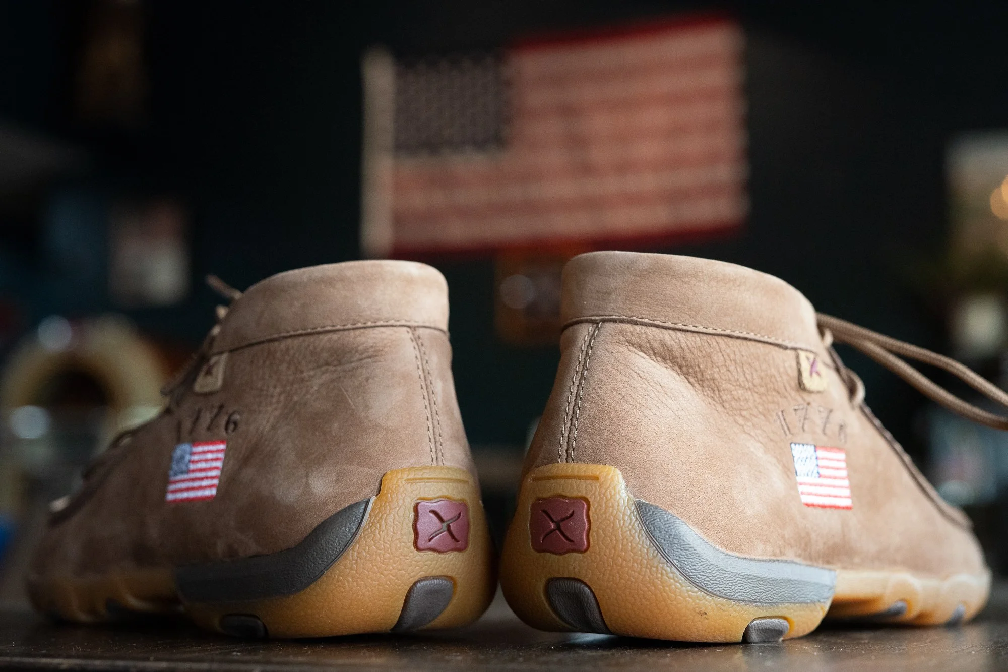 Close detail of Twisted X shoes with American flag patches inside a VFW hall