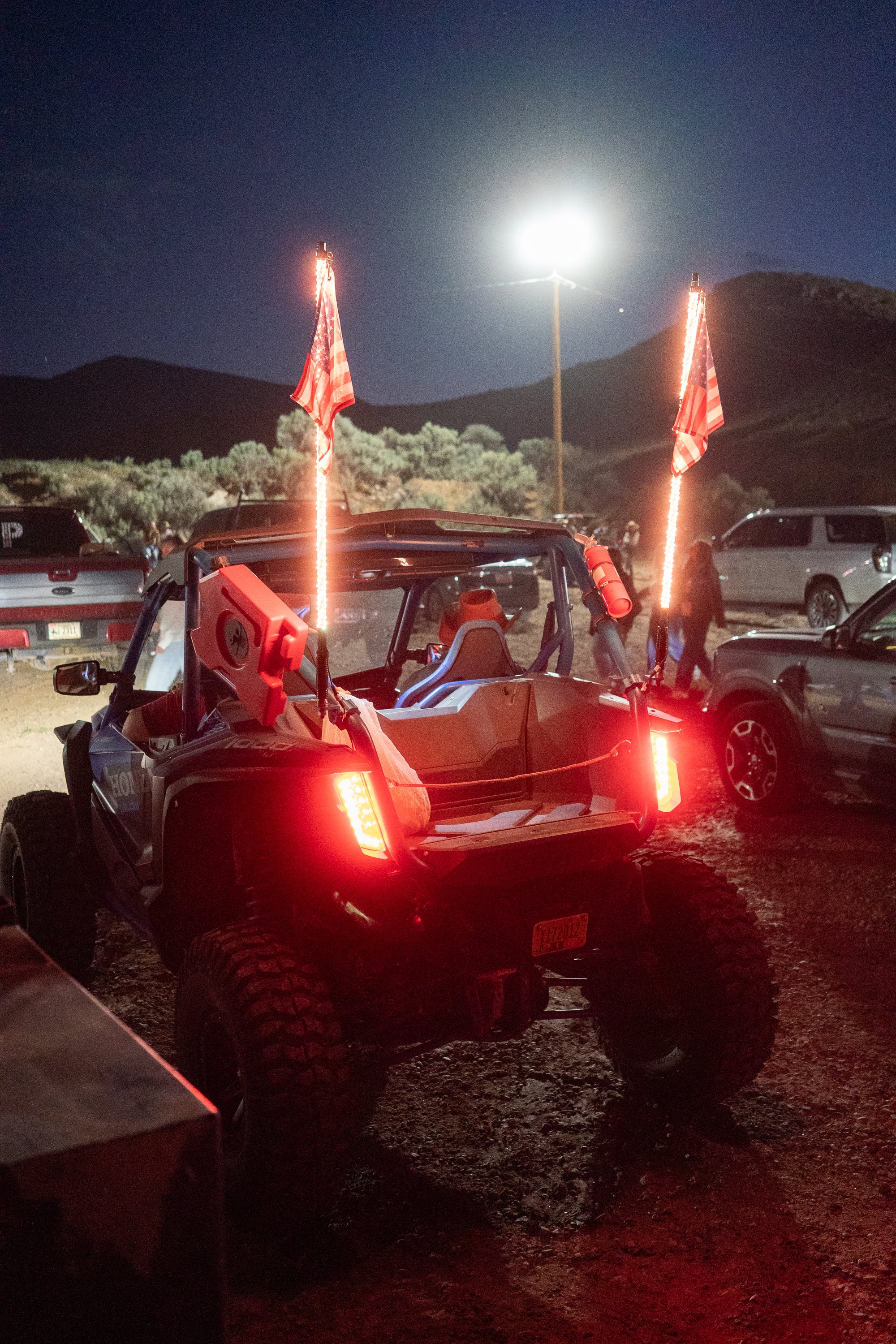 Side by side utility vehicle parked with American flags after the Dubois Rodeo in Wyoming