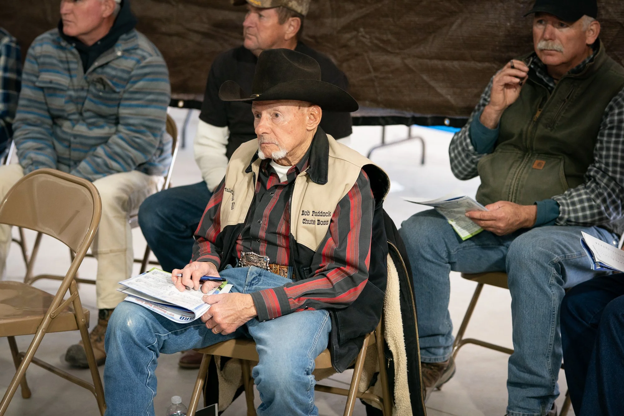 Ranchers seated with sale catalogs during a Nevada bull sale
