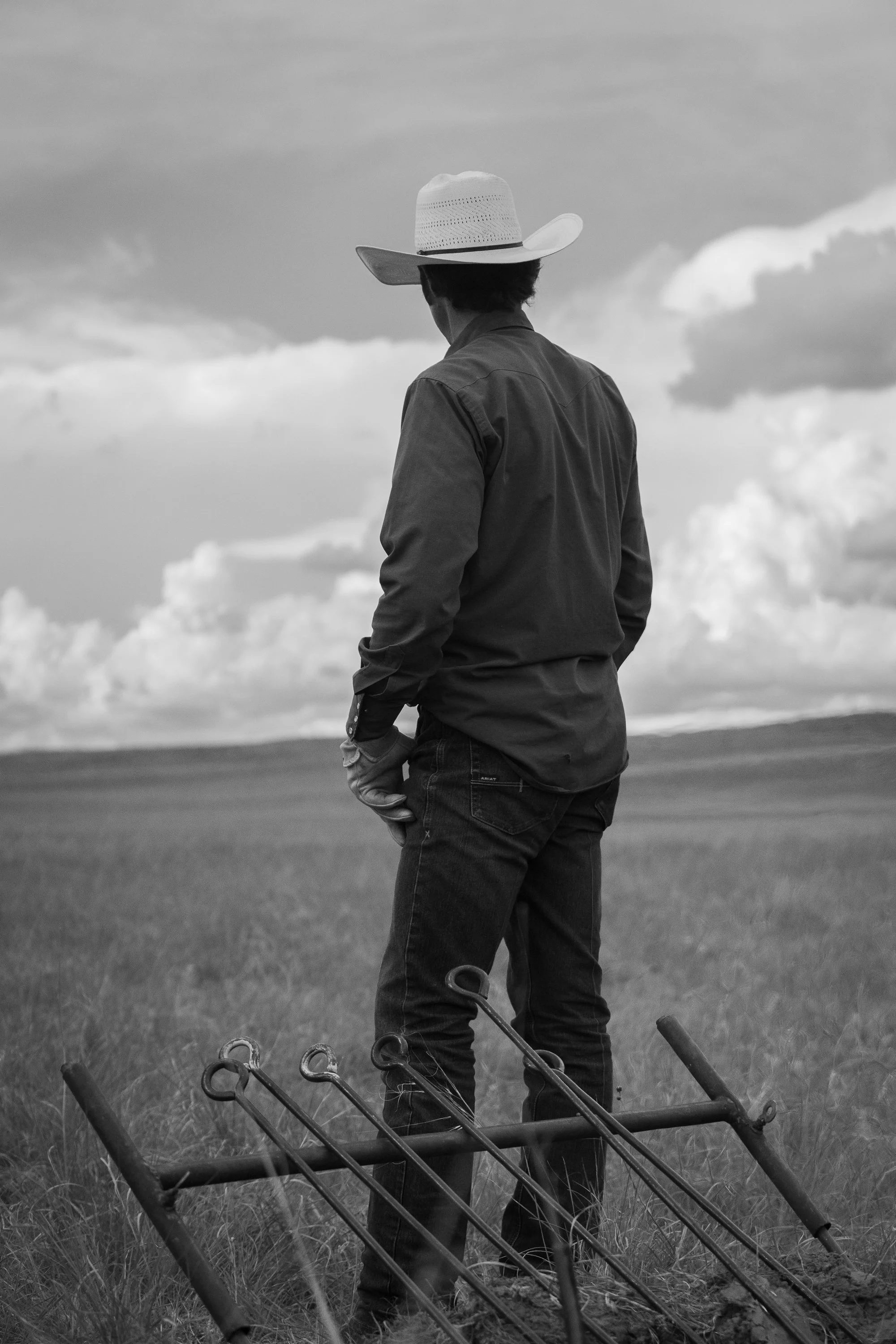 A cowboy stands near a rack of branding irons on the prairie at Haythorn Ranch in Nebraska.