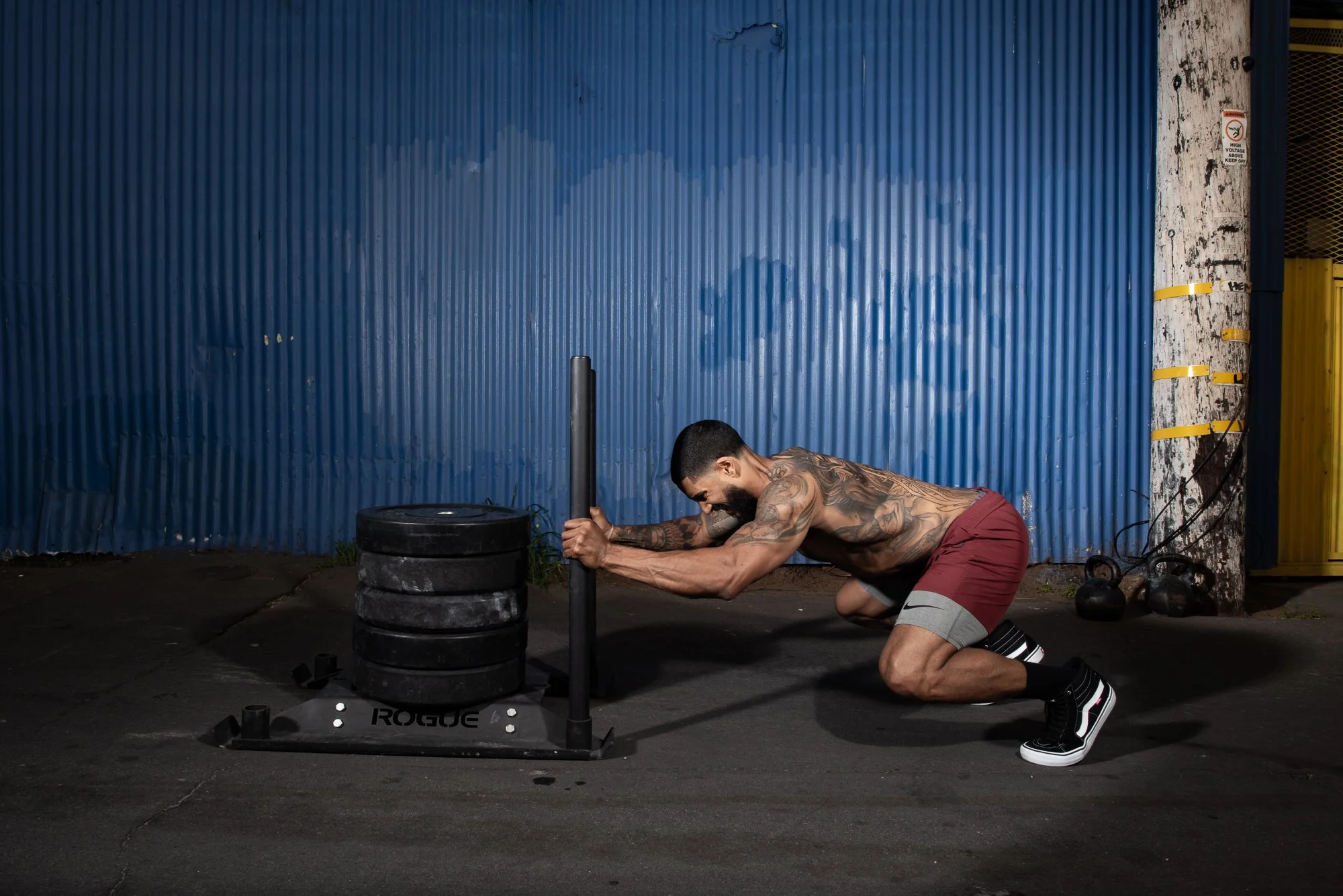 Athlete pushes a weighted sled across pavement in an outdoor Colorado training area