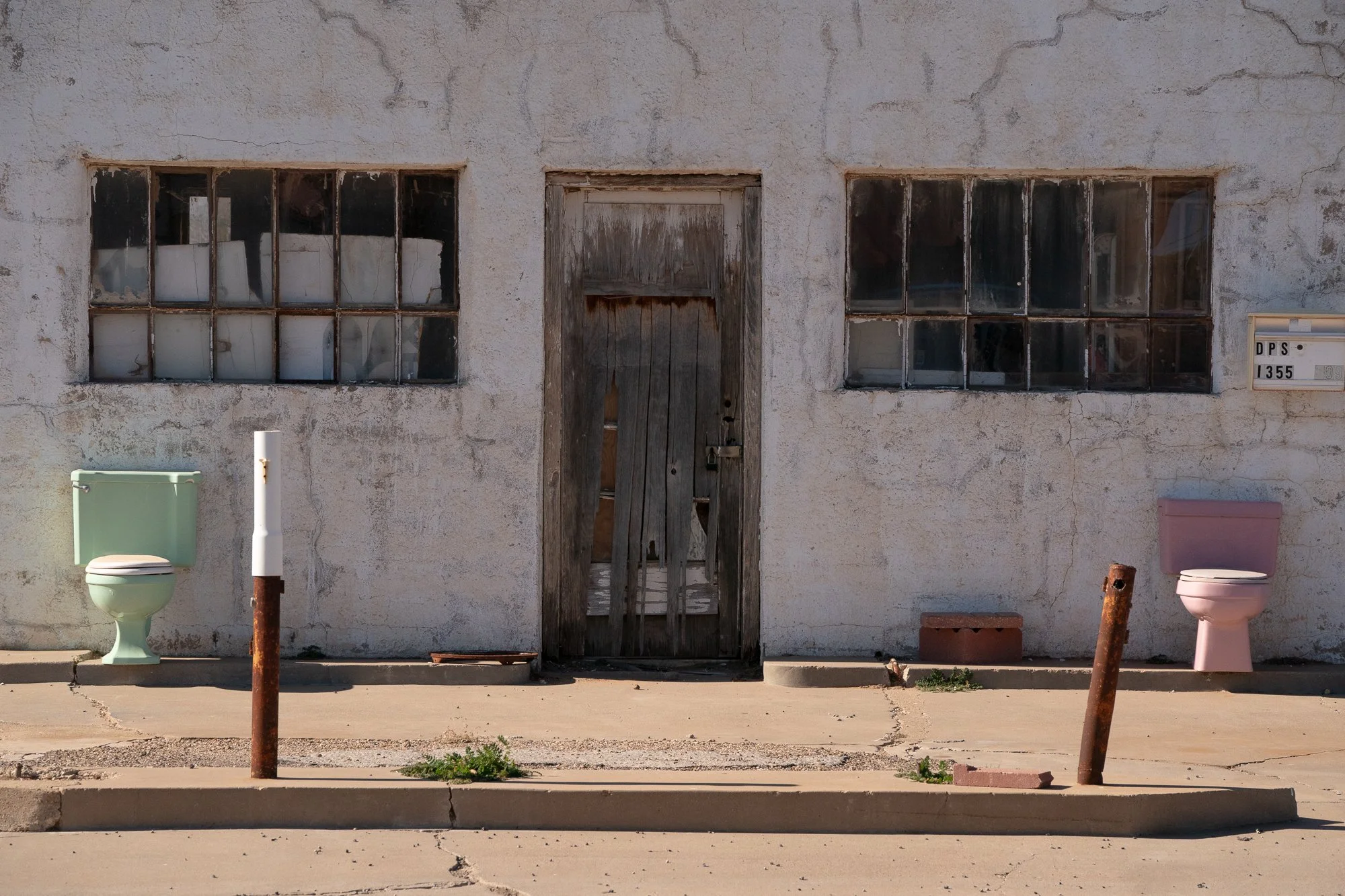 Abandoned building facade with pastel toilets outside on the Llano Estacado in Texas