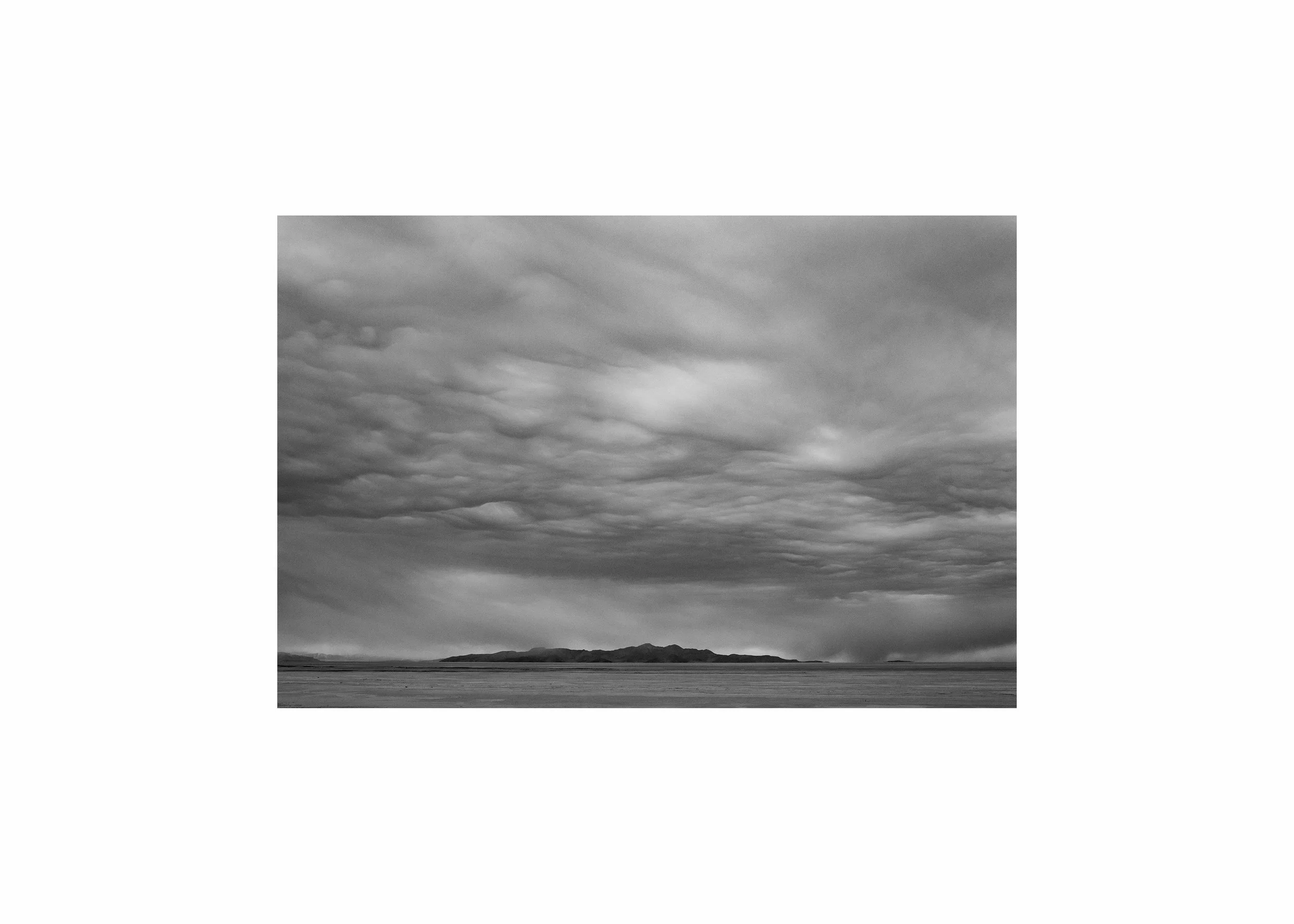 Dramatic black and white fine art print of a stormy sky over a minimalist desert landscape