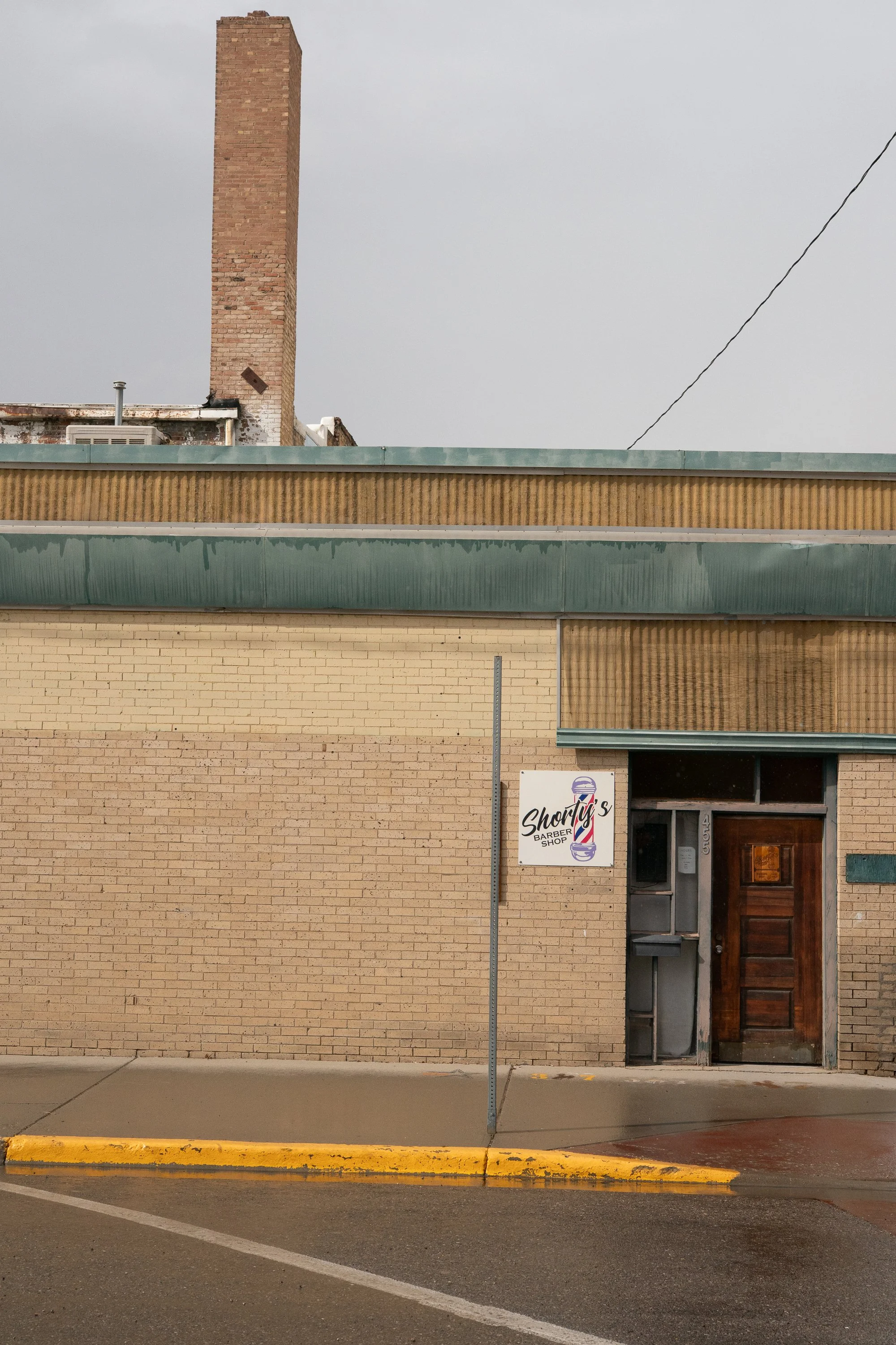 Weathered brick storefront with chimney and entrance in Wyoming