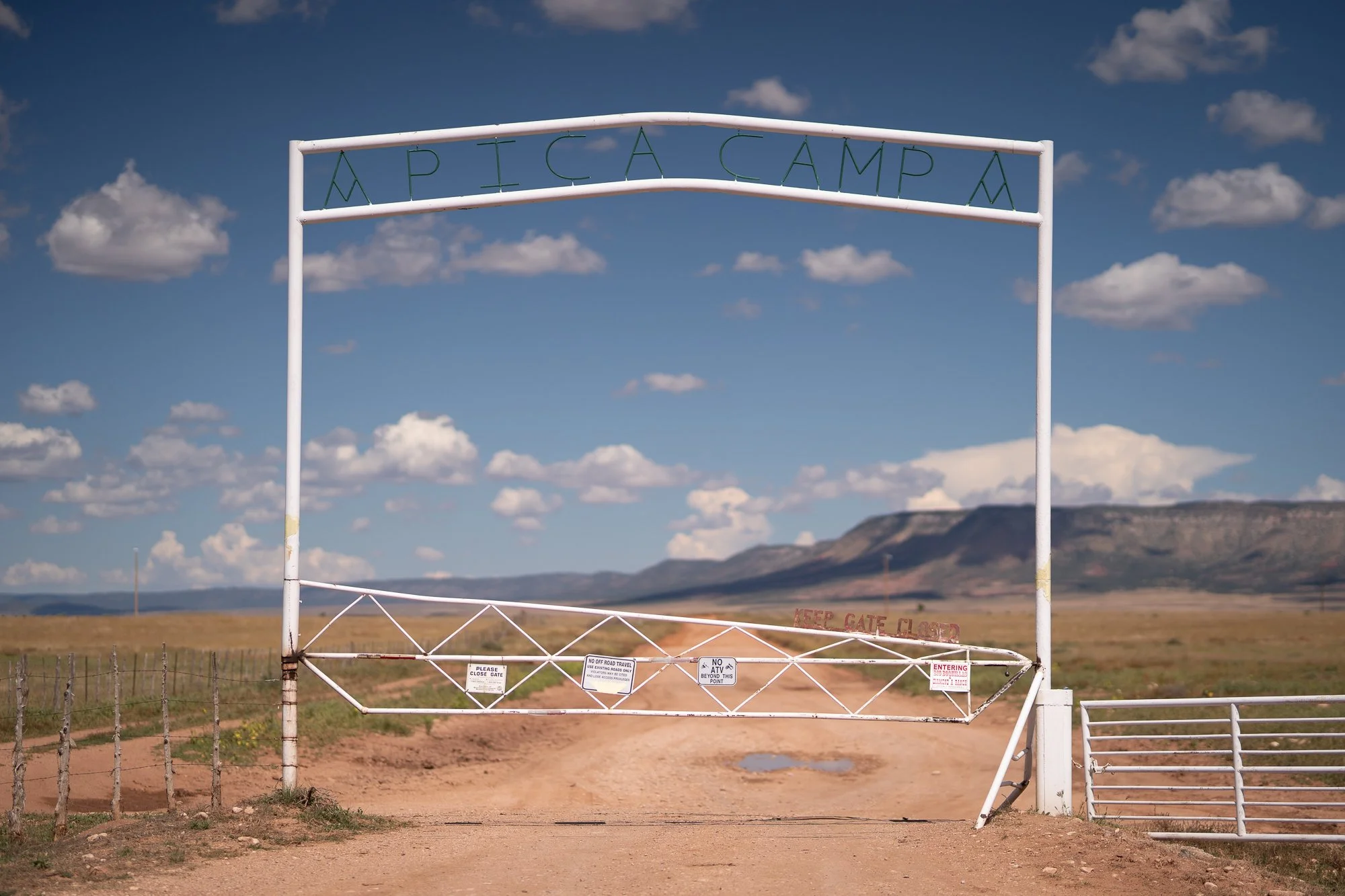 pica Camp ranch entrance gate in the Arizona desert with mountains in the background