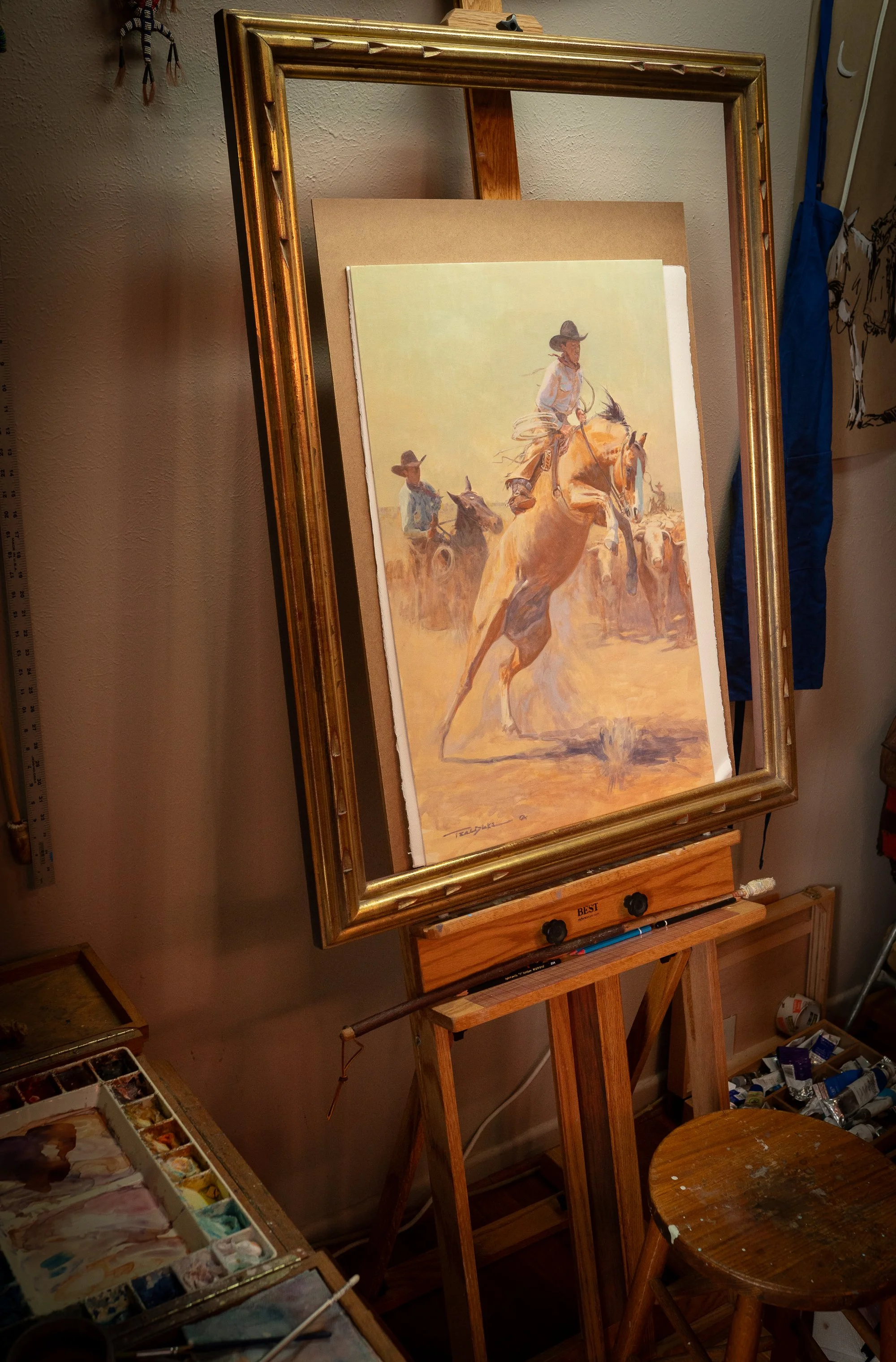 Framed Western cowboy painting by Teal Blake displayed on studio easel