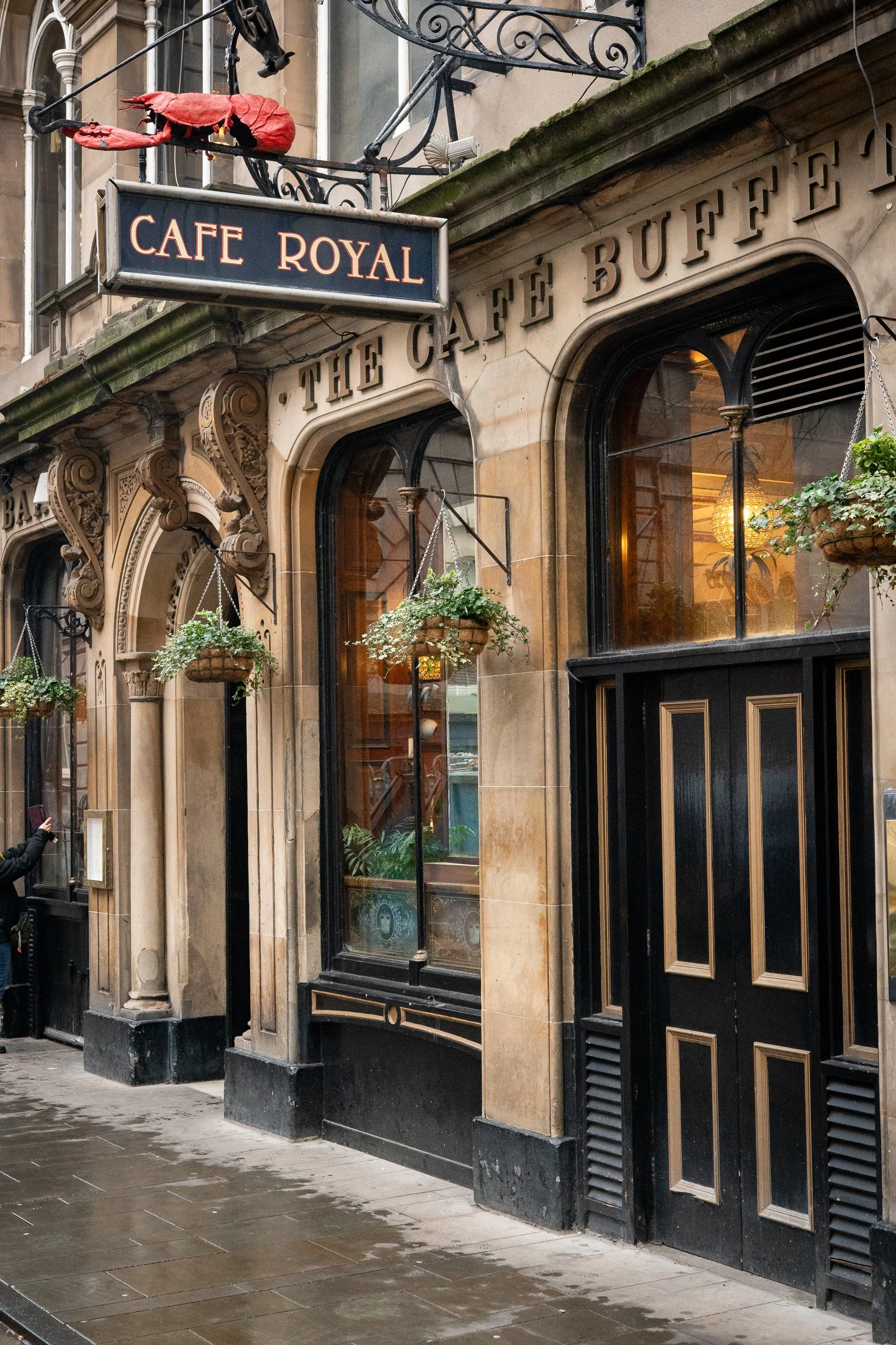 Exterior facade of Cafe Royal in Edinburgh with hanging plants and ornate stonework