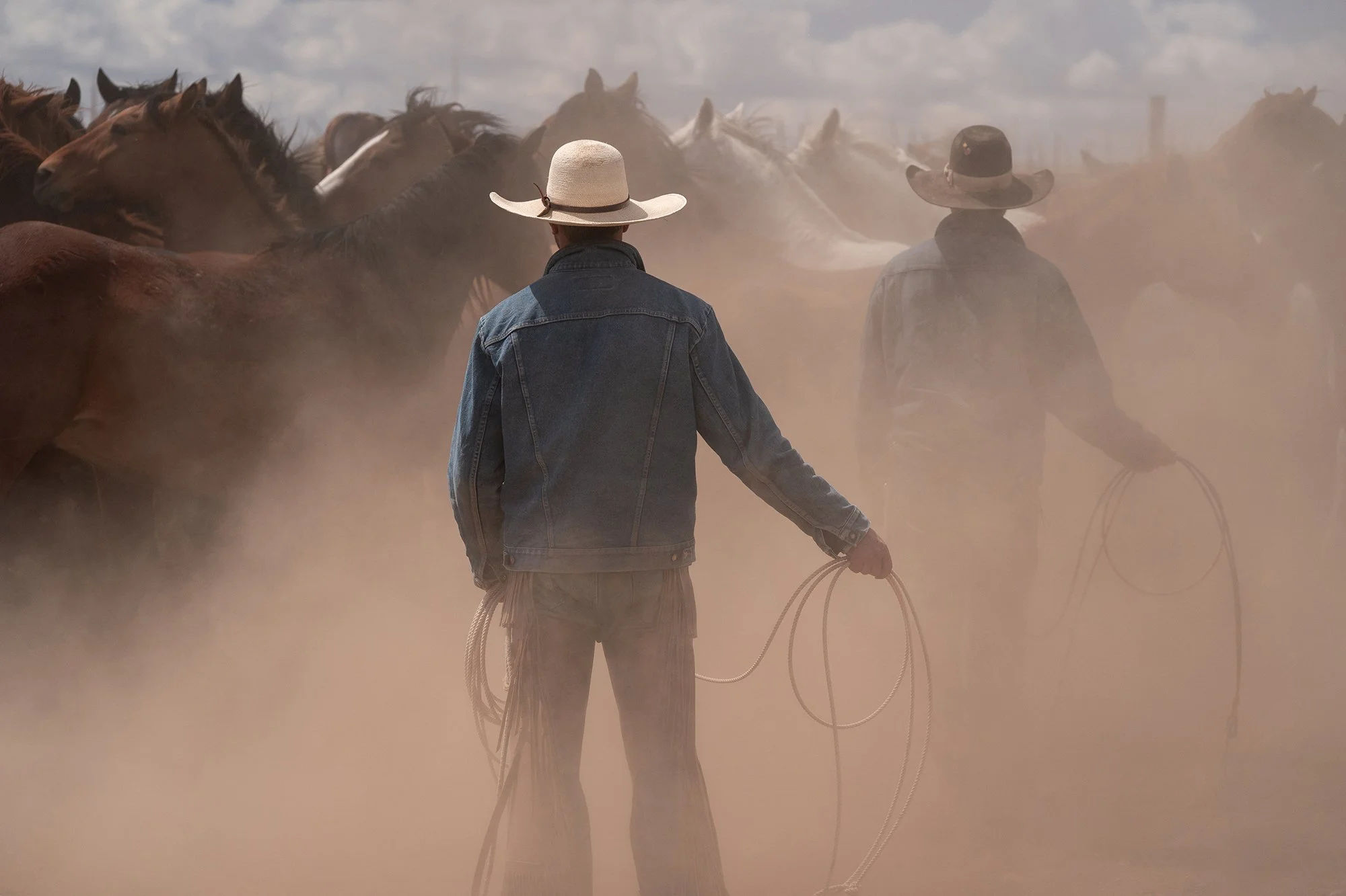 Limited edition fine art photography print of cowboys in a dusty corral with horses
