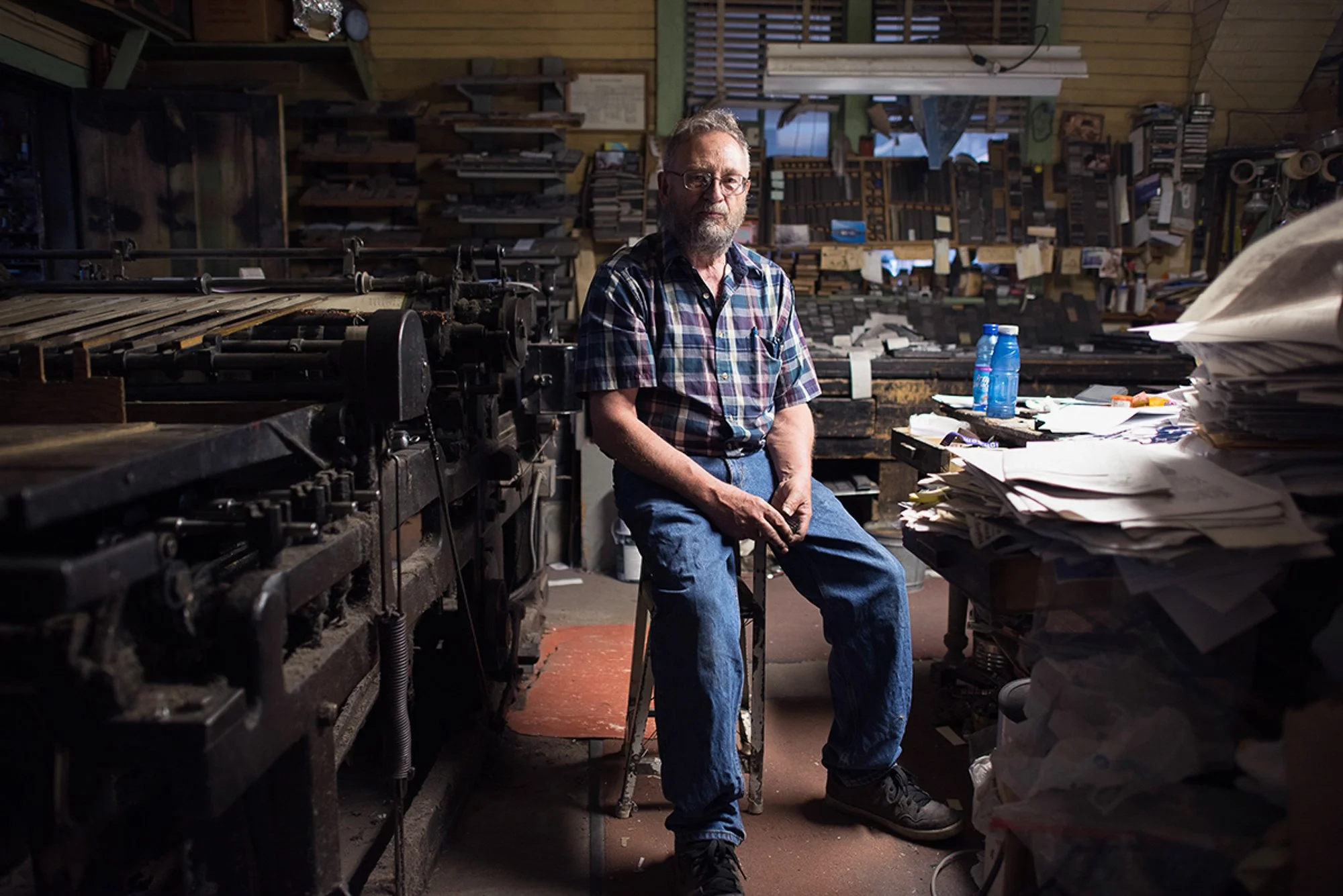 Dean Coombs seated inside the Saguache Crescent newspaper office