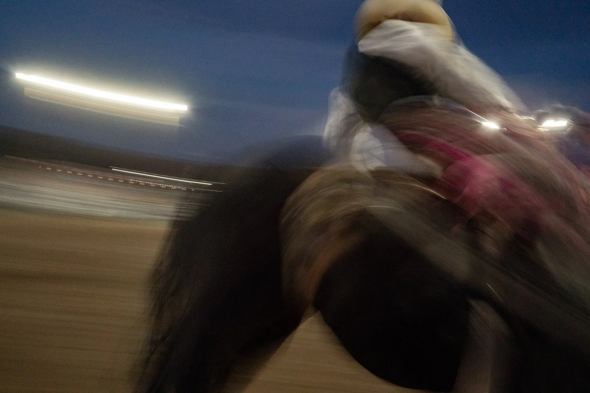 Cowboy riding a horse at a Wyoming rodeo in low light