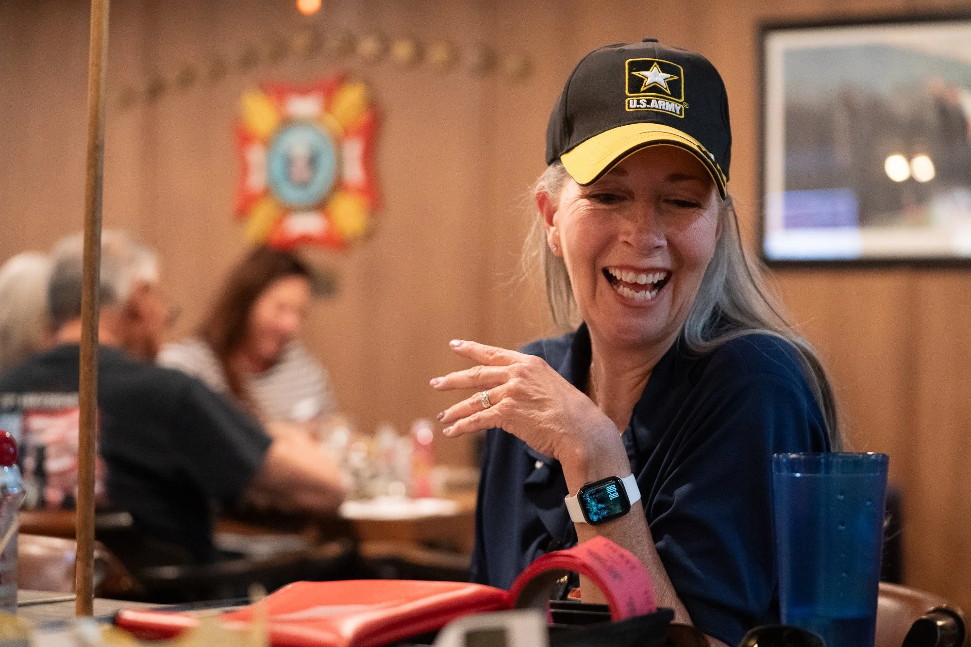 Veteran wearing a U.S. Army hat seated at a table inside a VFW hall during a brand campaign