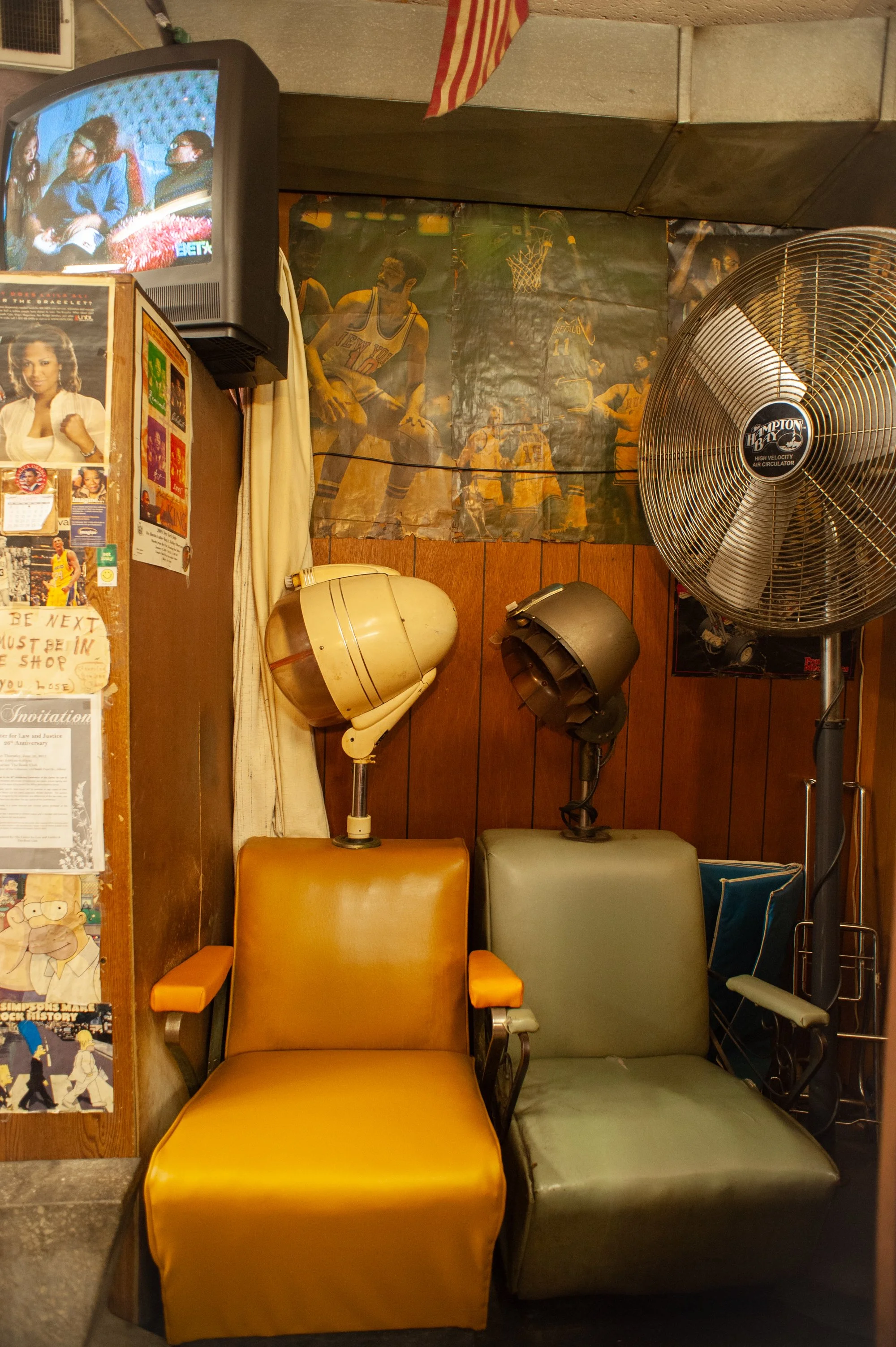 Old hair dryers and posters on the wall inside a classic barbershop interior