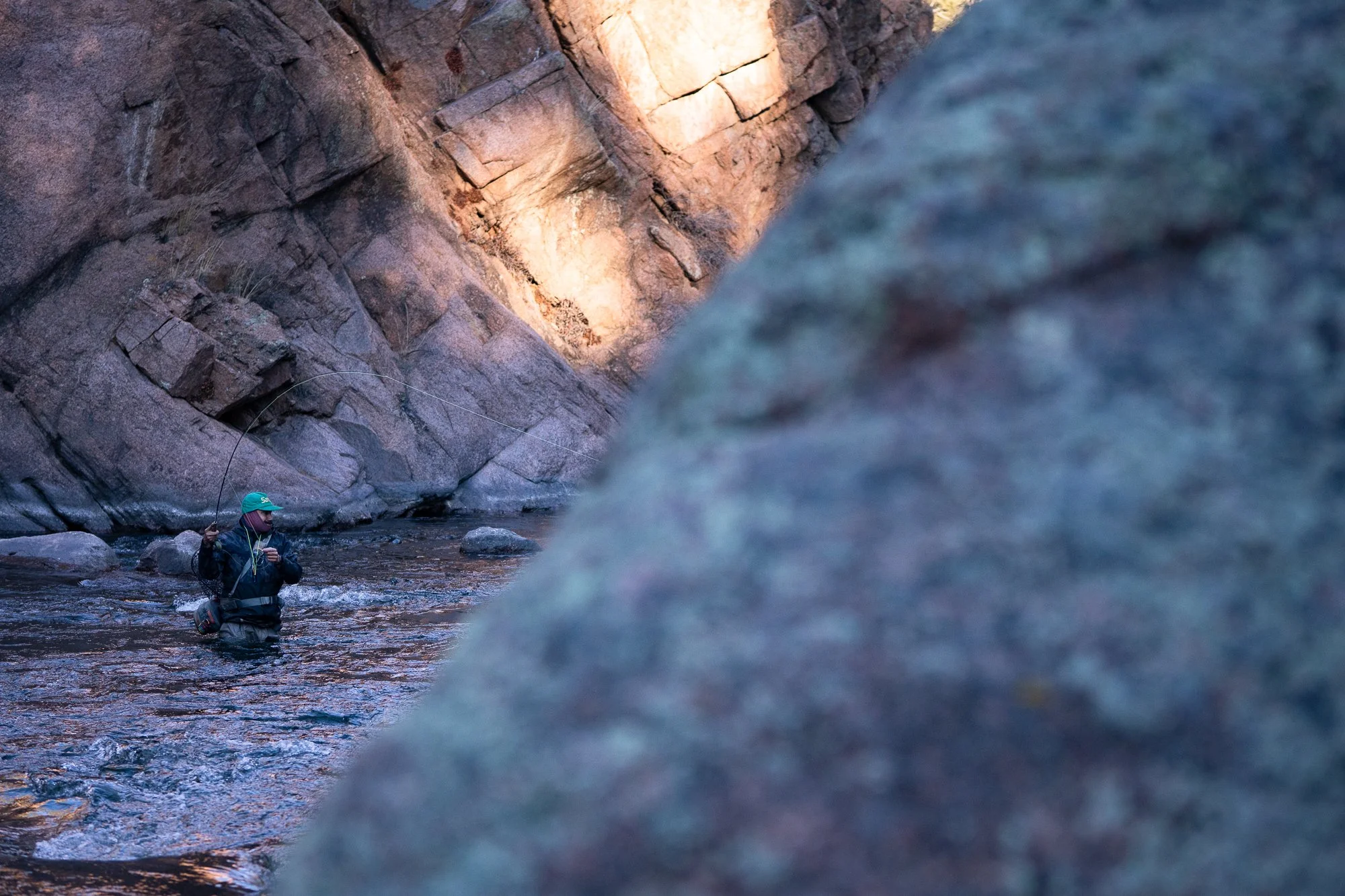 Angler fly fishing through a narrow rocky stretch of the South Platte River near Deckers