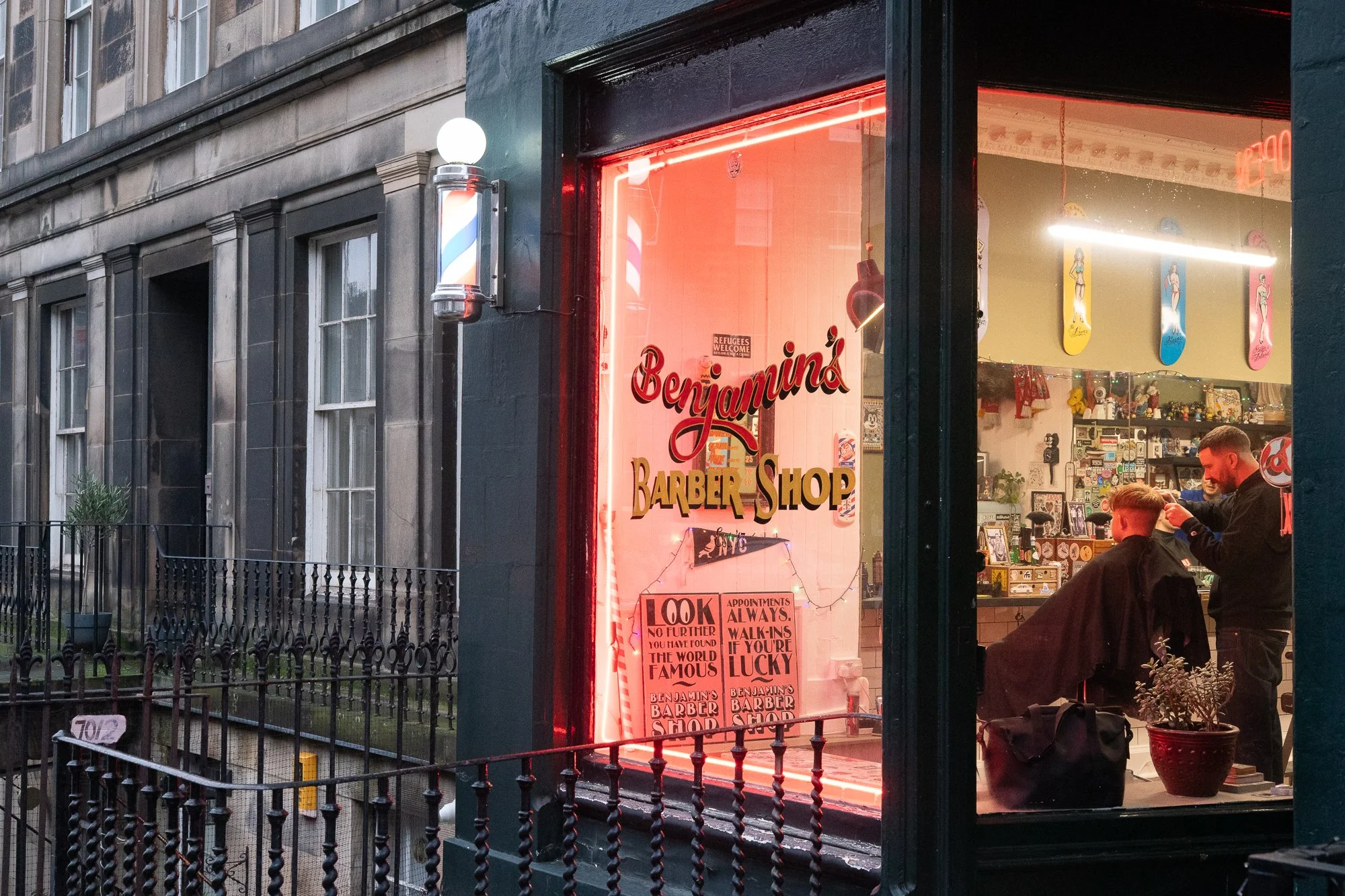 benjamins barber shop window with red neon glow in edinburgh street