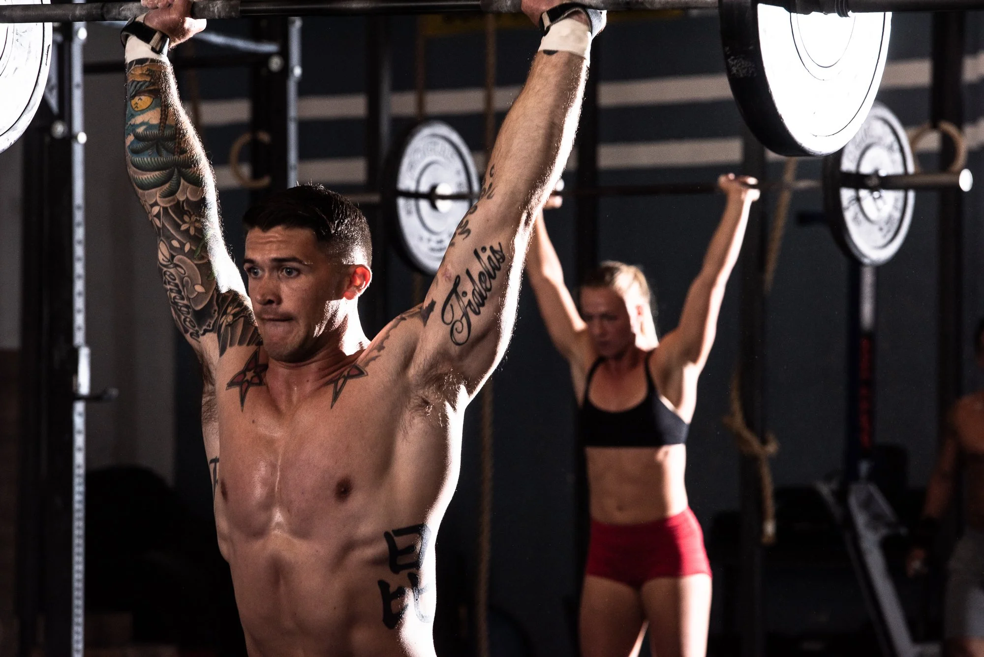 CrossFit athletes holding barbells overhead during functional fitness training in Boulder, Colorado.