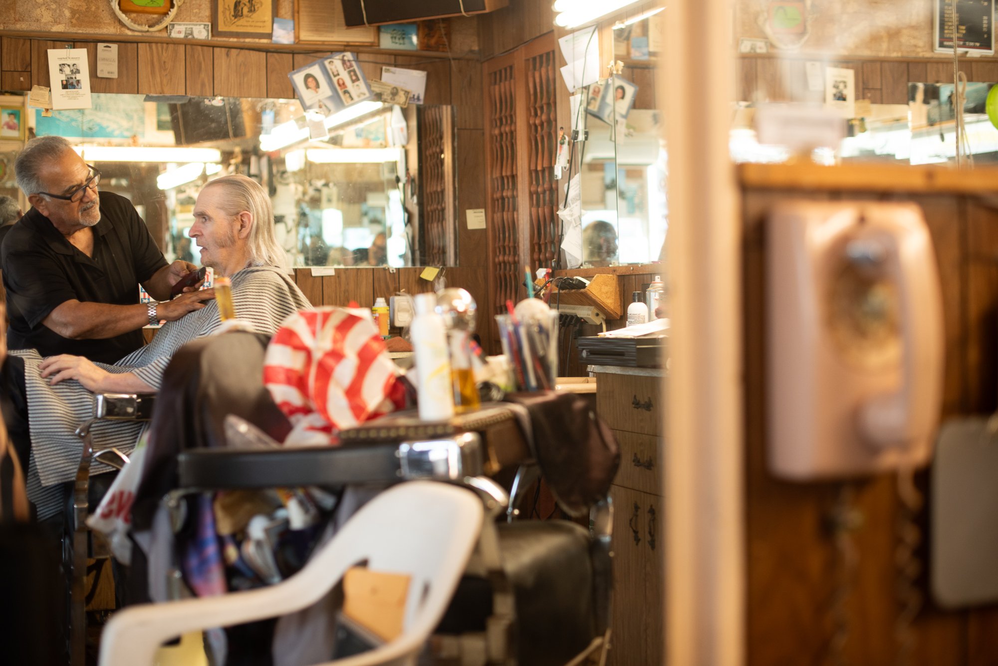 Customer getting a haircut in a traditional barbershop in San Diego, California documentary image