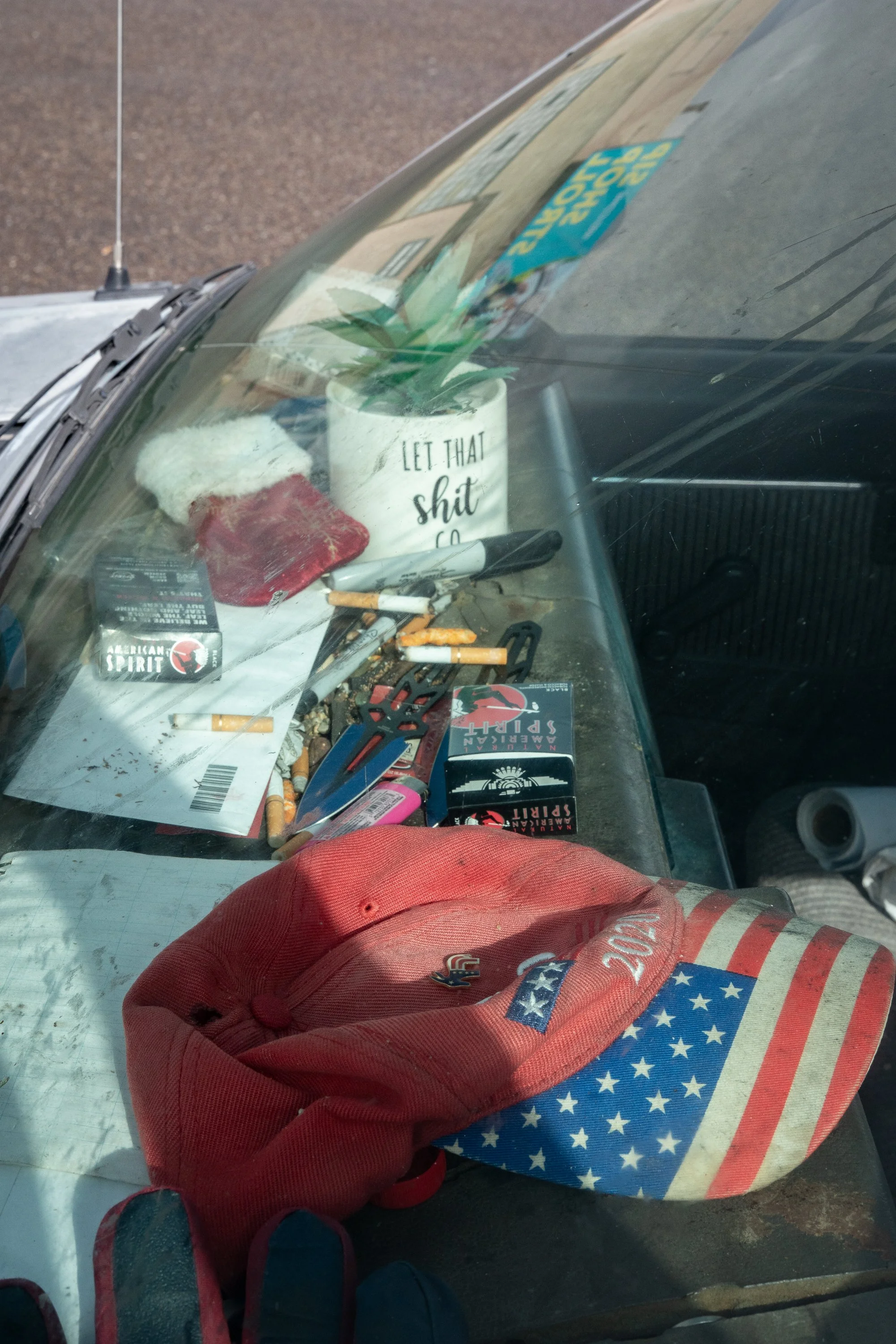 Dashboard of pickup truck cluttered with cigarettes hat and small objects in Rock Springs Wyoming