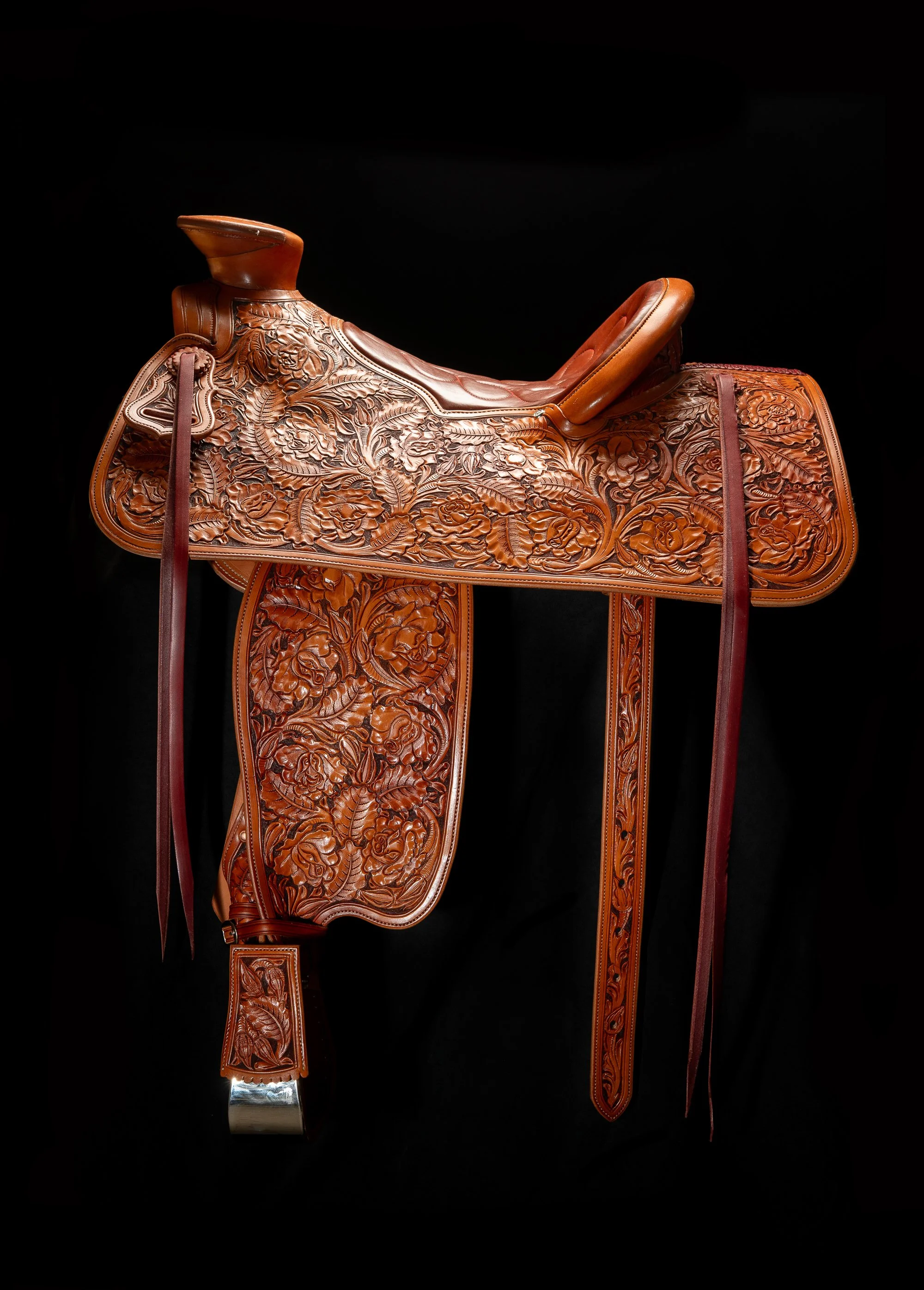 Finished Mother Hubbard Western saddle with extensive floral leather tooling.