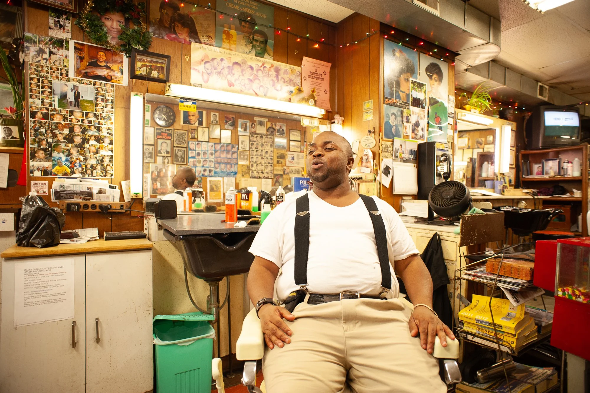Barber sitting in barber chair at Stancil’s Barbershop Albany NY, Black barbershop culture documented in 2011