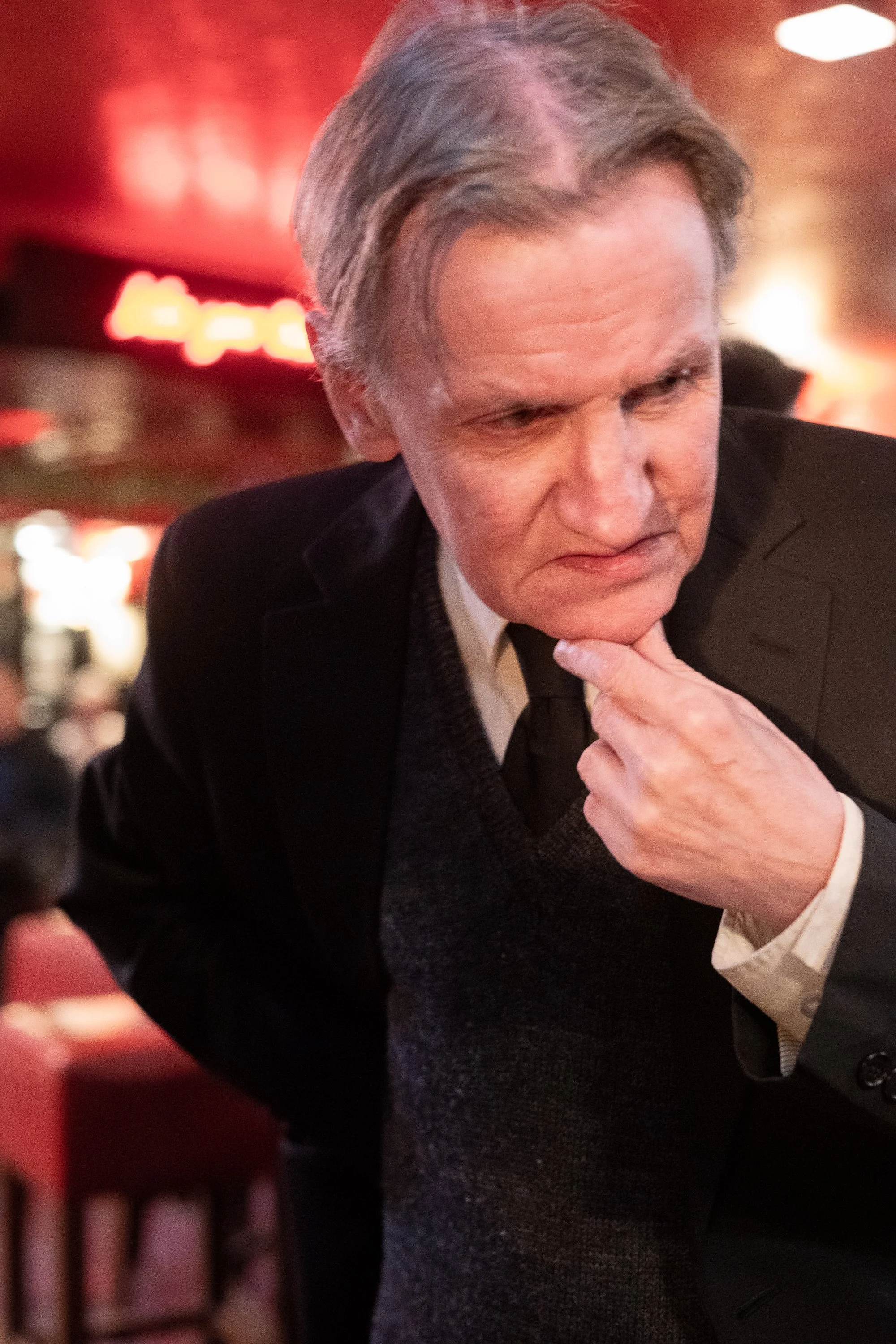 Portrait of man in suit standing thoughtfully inside Edinburgh pub