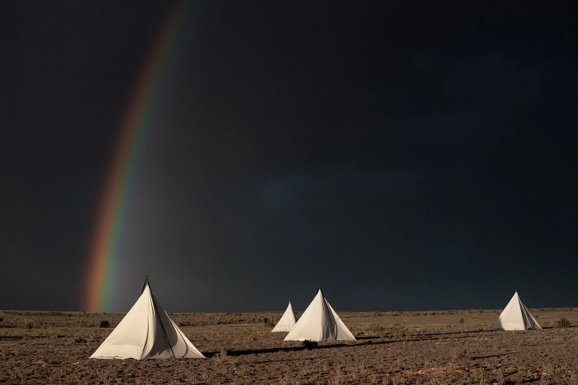 Canvas tents beneath a rainbow on the Diamond A Ranch in Arizona