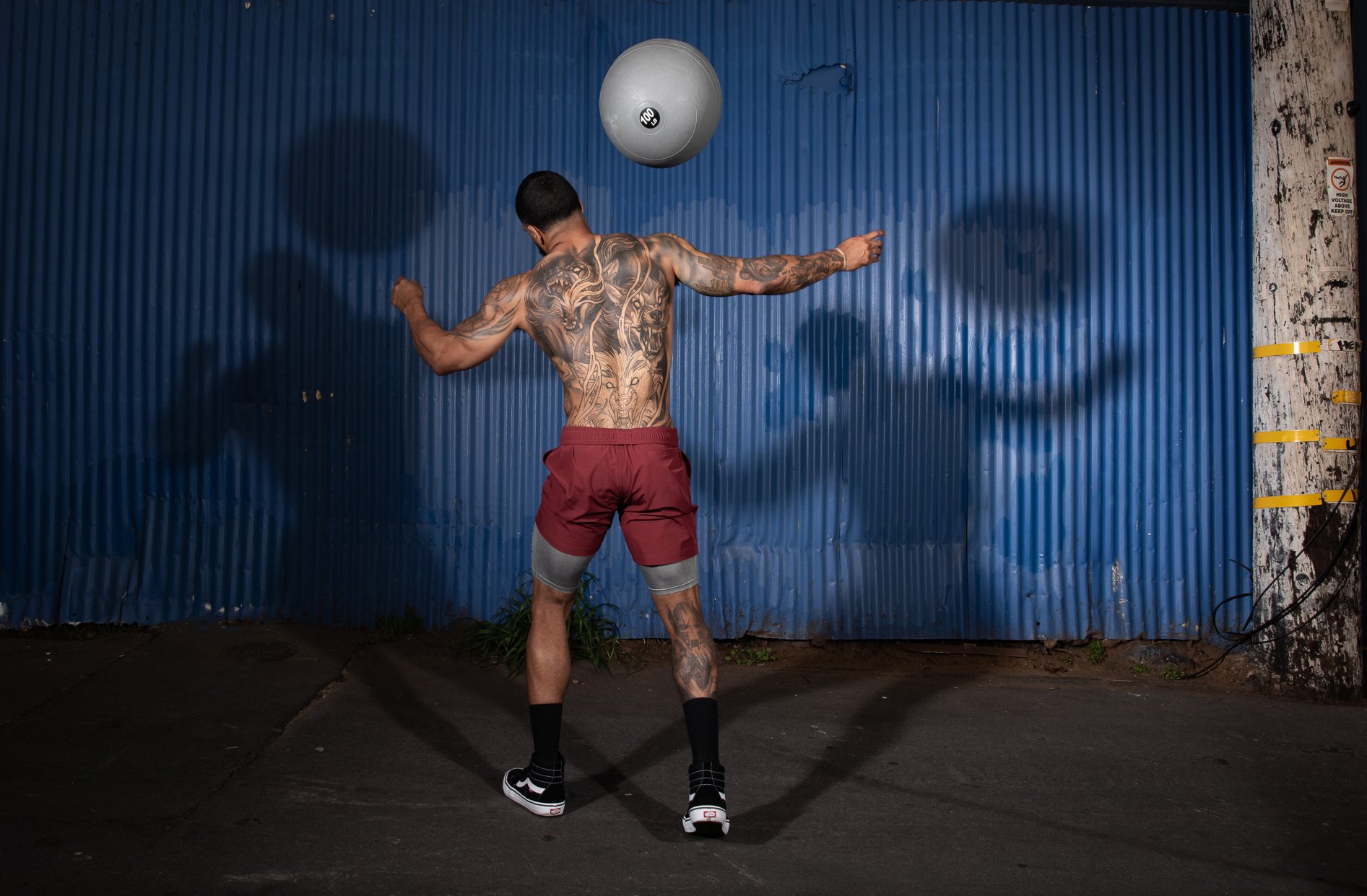 Athlete throws a medicine ball upward against a wall in an outdoor Colorado training area