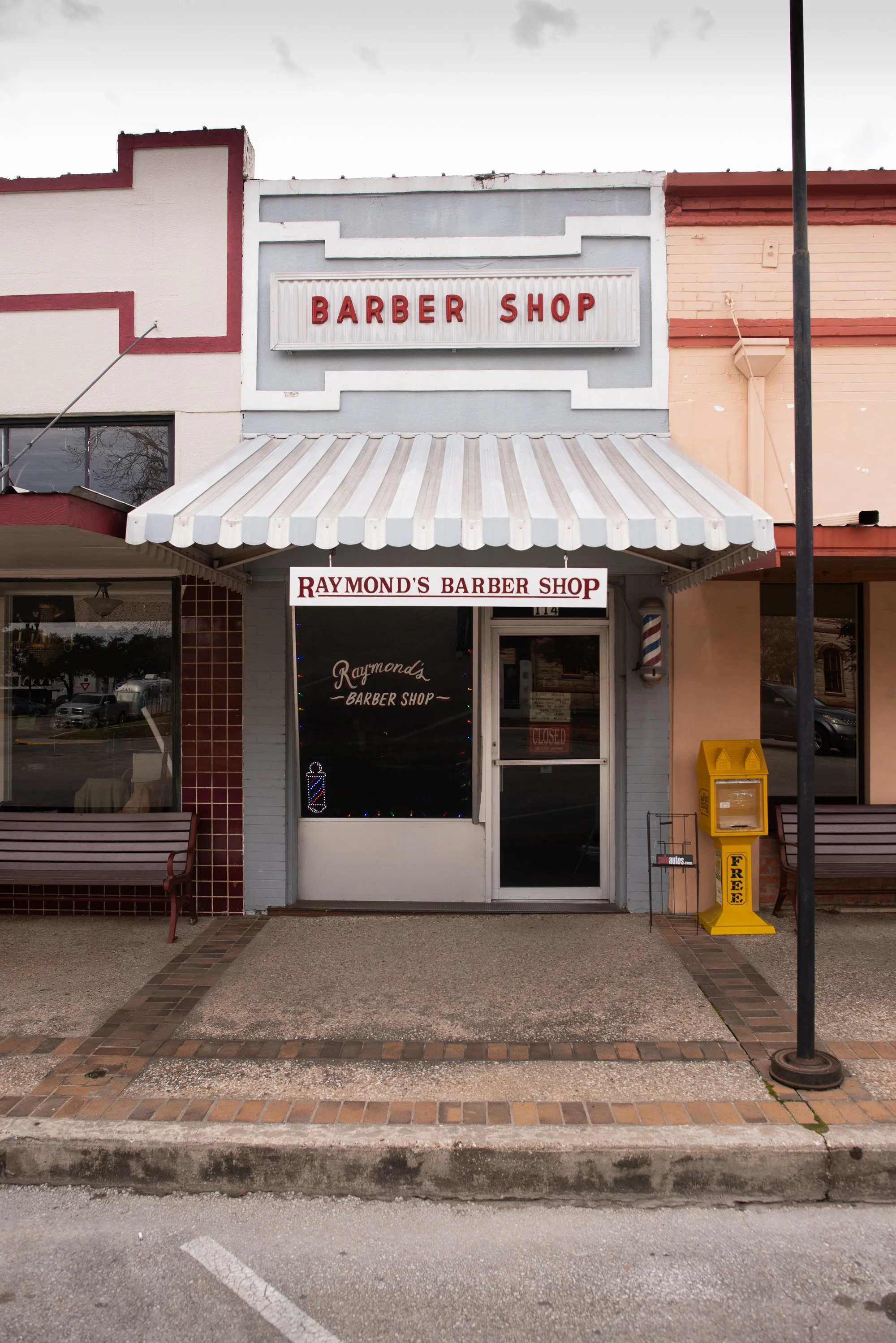 Exterior storefront of Raymond’s Barber Shop in downtown Lockhart, Texas.