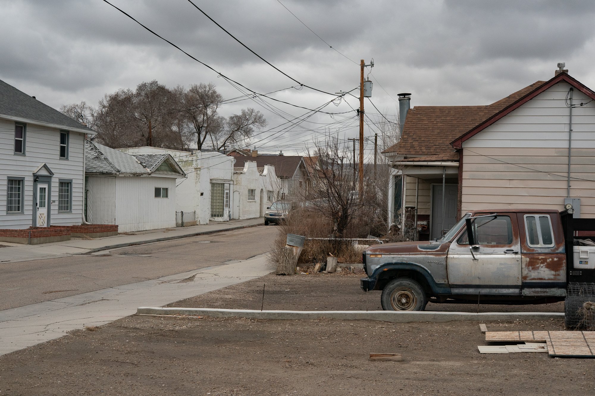 Old rusted pickup truck parked beside a residential street in Rock Springs Wyoming
