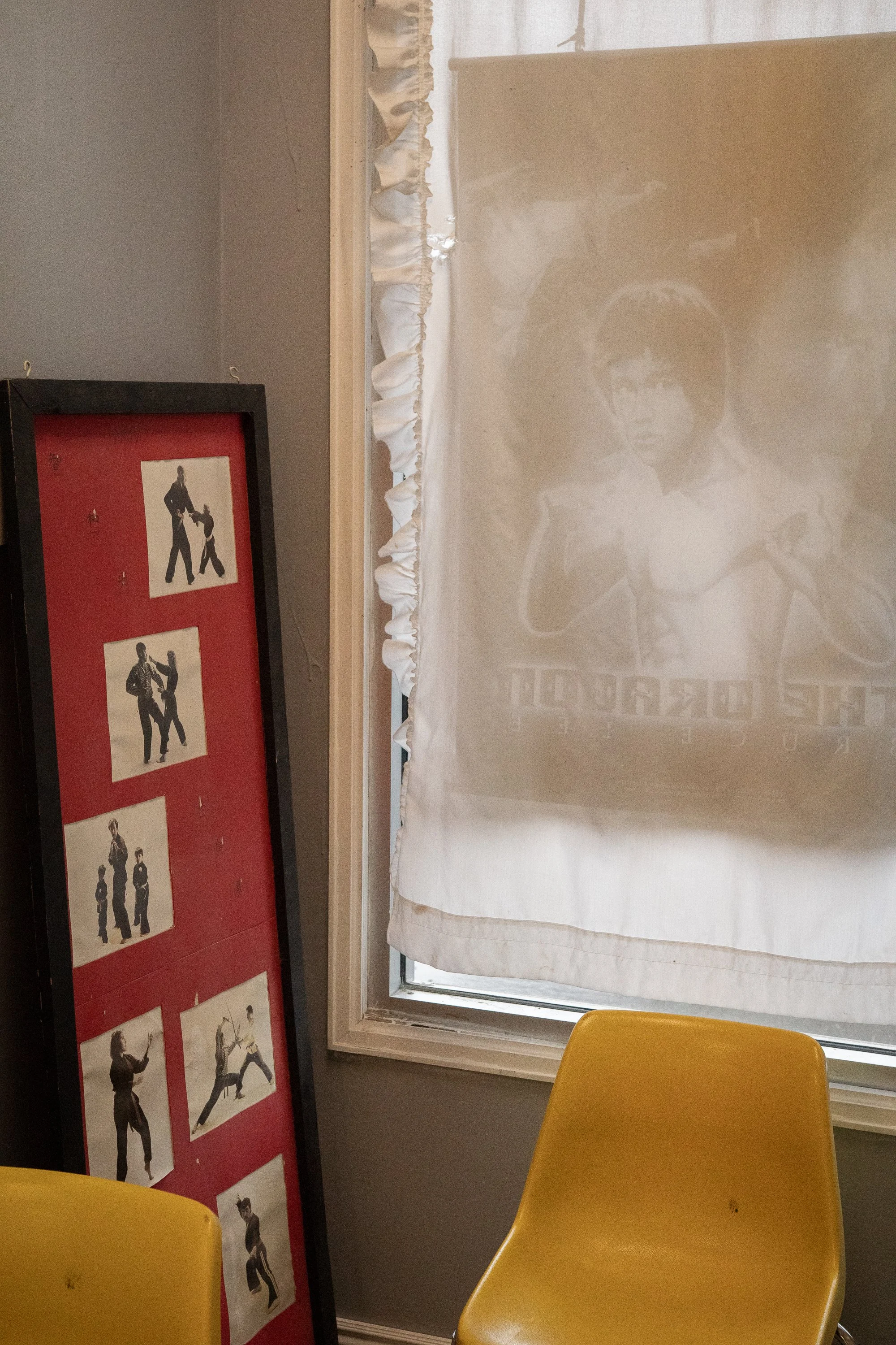 Bruce Lee poster visible through curtain beside martial arts photos in Rock Springs Wyoming
