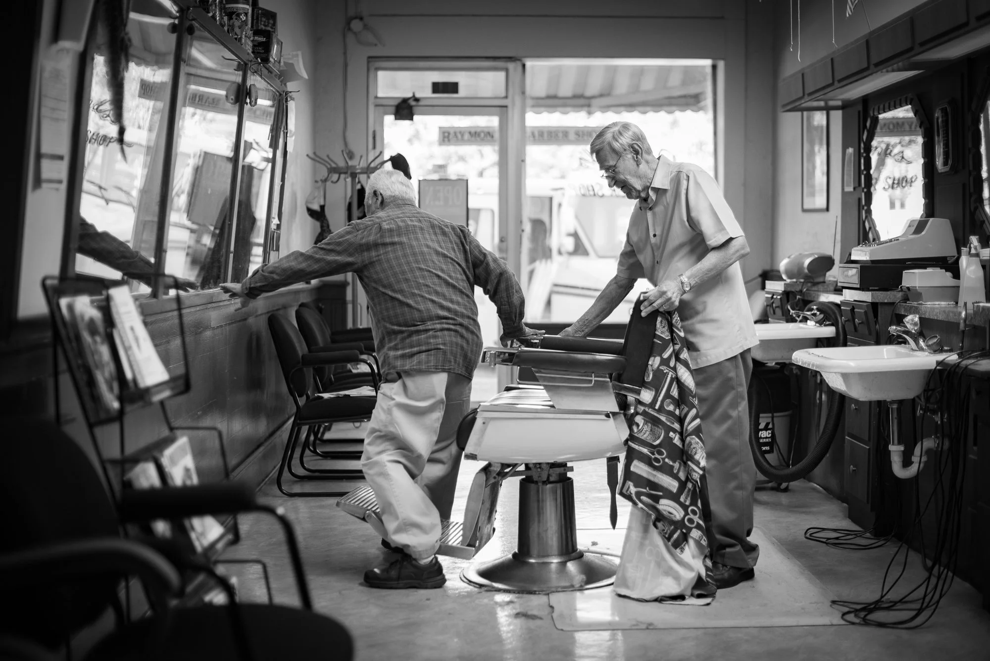 An elderly man sits in a barber chair inside Raymond’s Barber Shop in Lockhart, Texas.