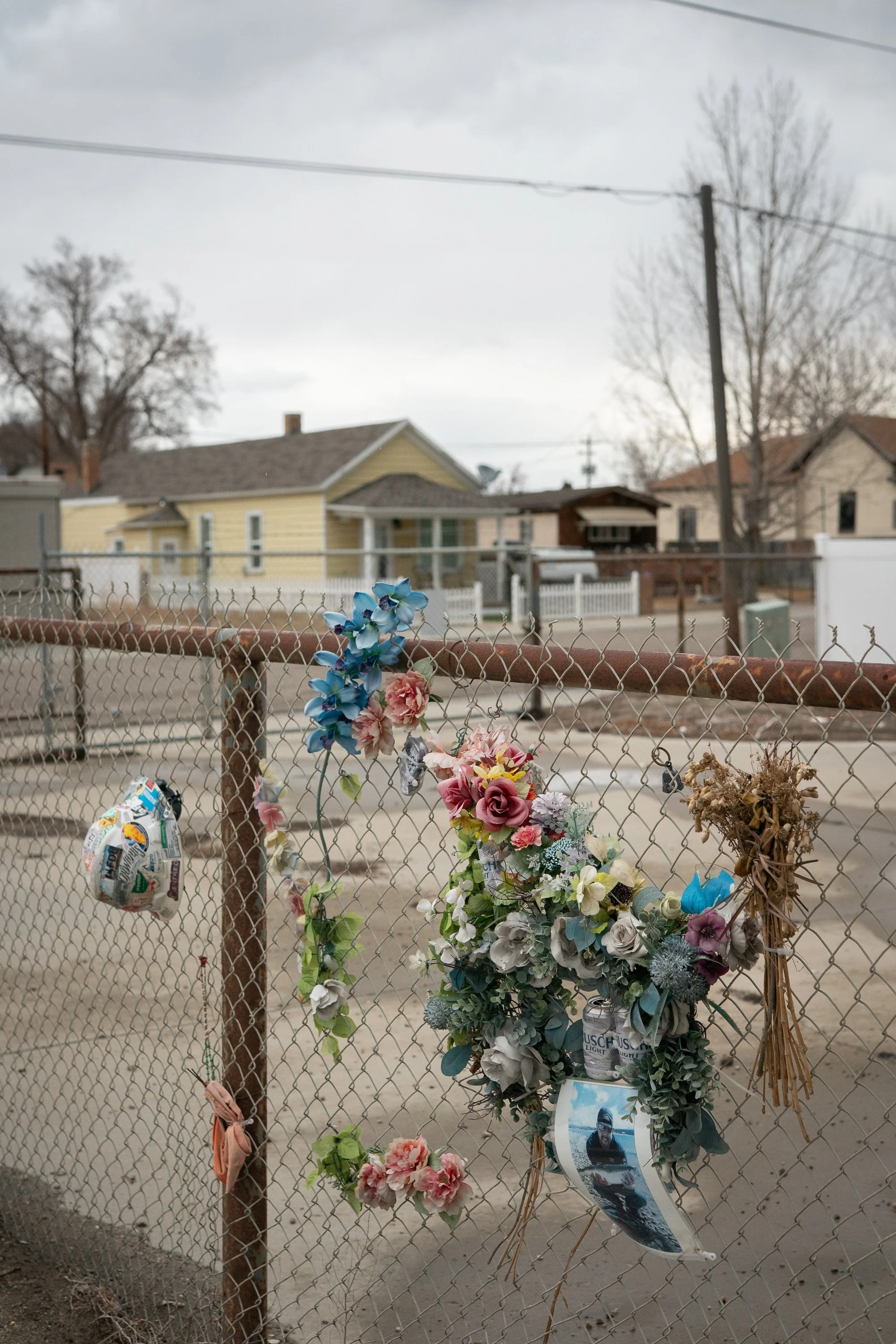 Flowers and memorial decorations attached to chain link fence in Rock Springs Wyoming