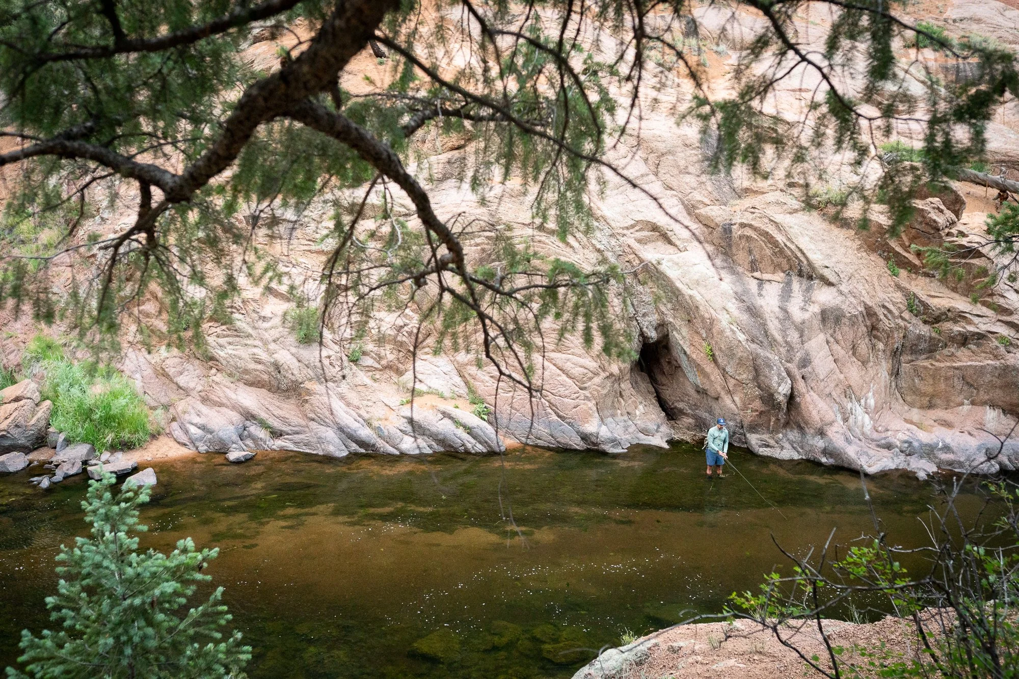 Angler fly fishing below rock walls along the South Platte River in Deckers Canyon