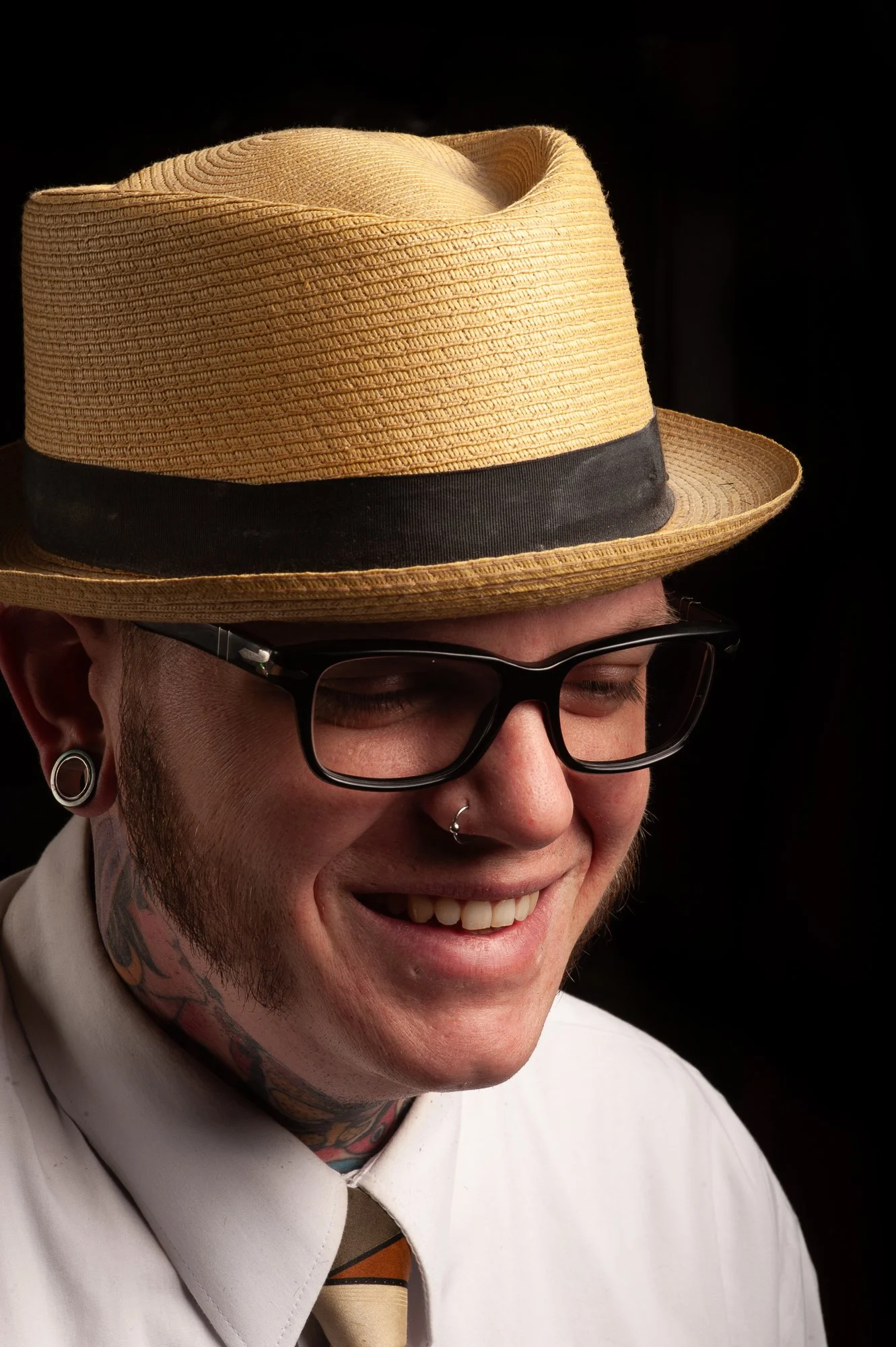 Barber portrait at Pugsly's Barbershop in Kingston, New York, wearing a straw hat and glasses.