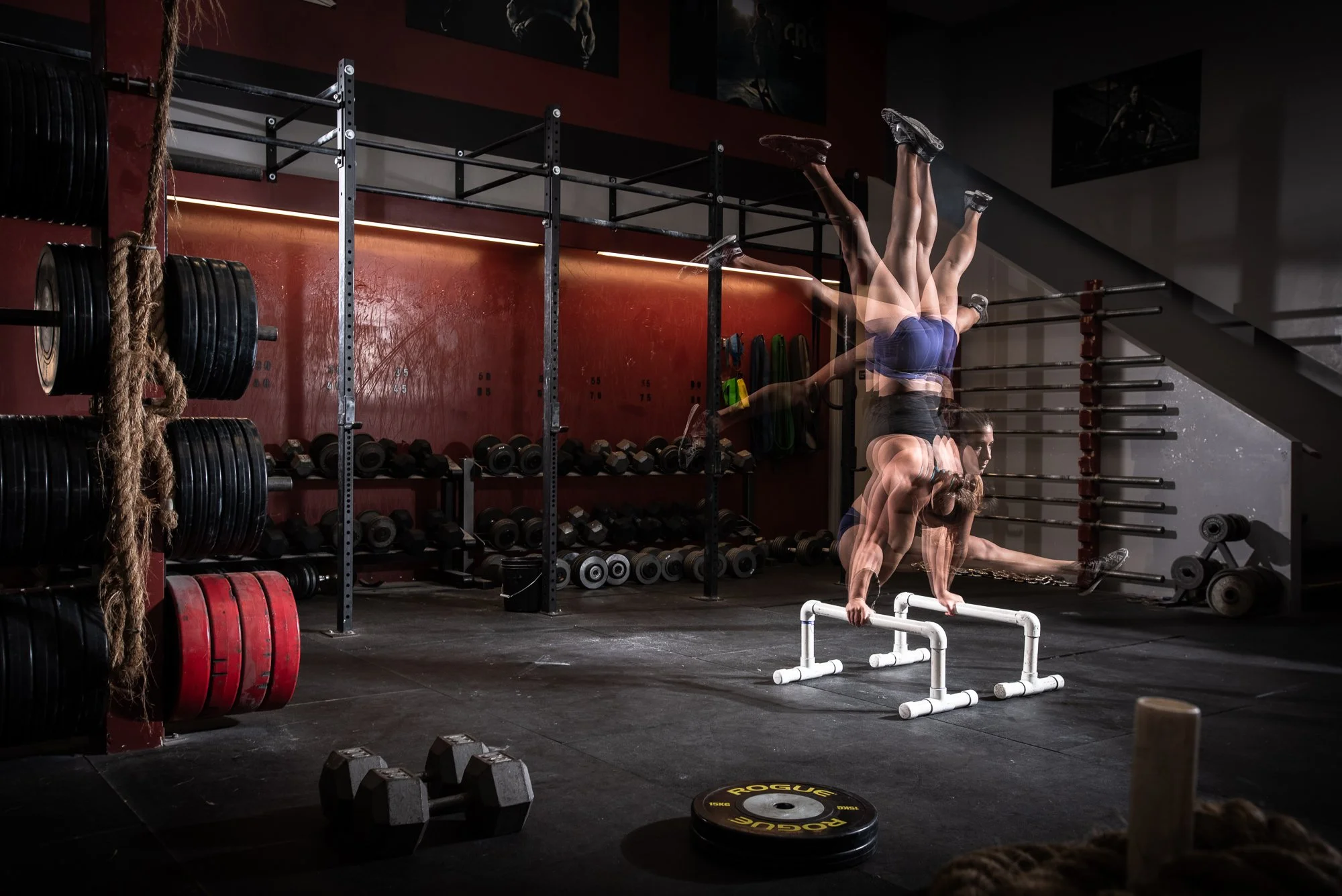 multiple exposure fitness photography of athlete performing handstand movement in gym training environment