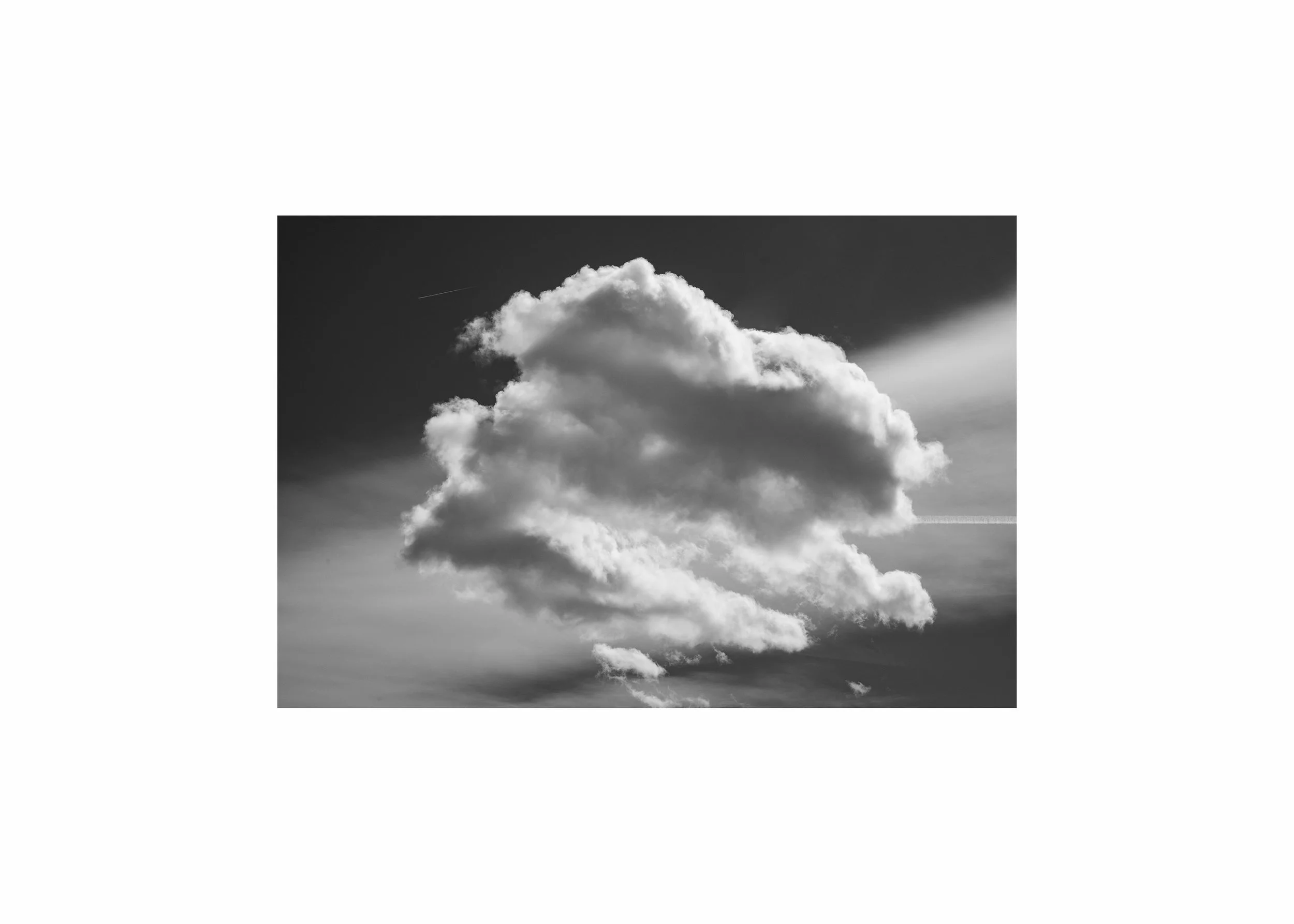 Minimalist black and white photograph of a single cloud floating in an open sky, creating a calm, biophilic wall art print with soft contrast and negative space.