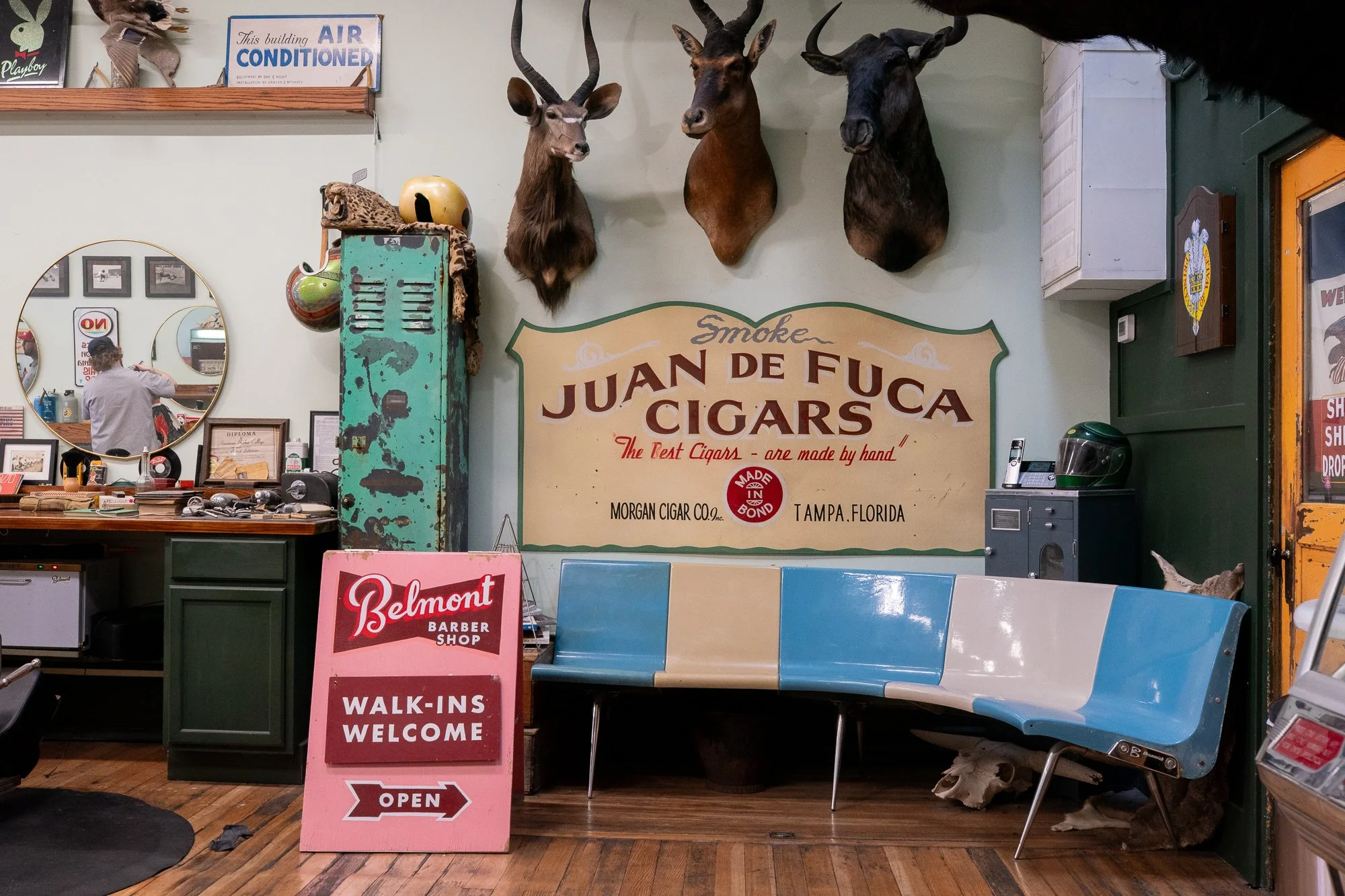 vintage waiting area inside Belmont Barbershop in Boise Idaho with walk-ins welcome sign and mounted animal heads