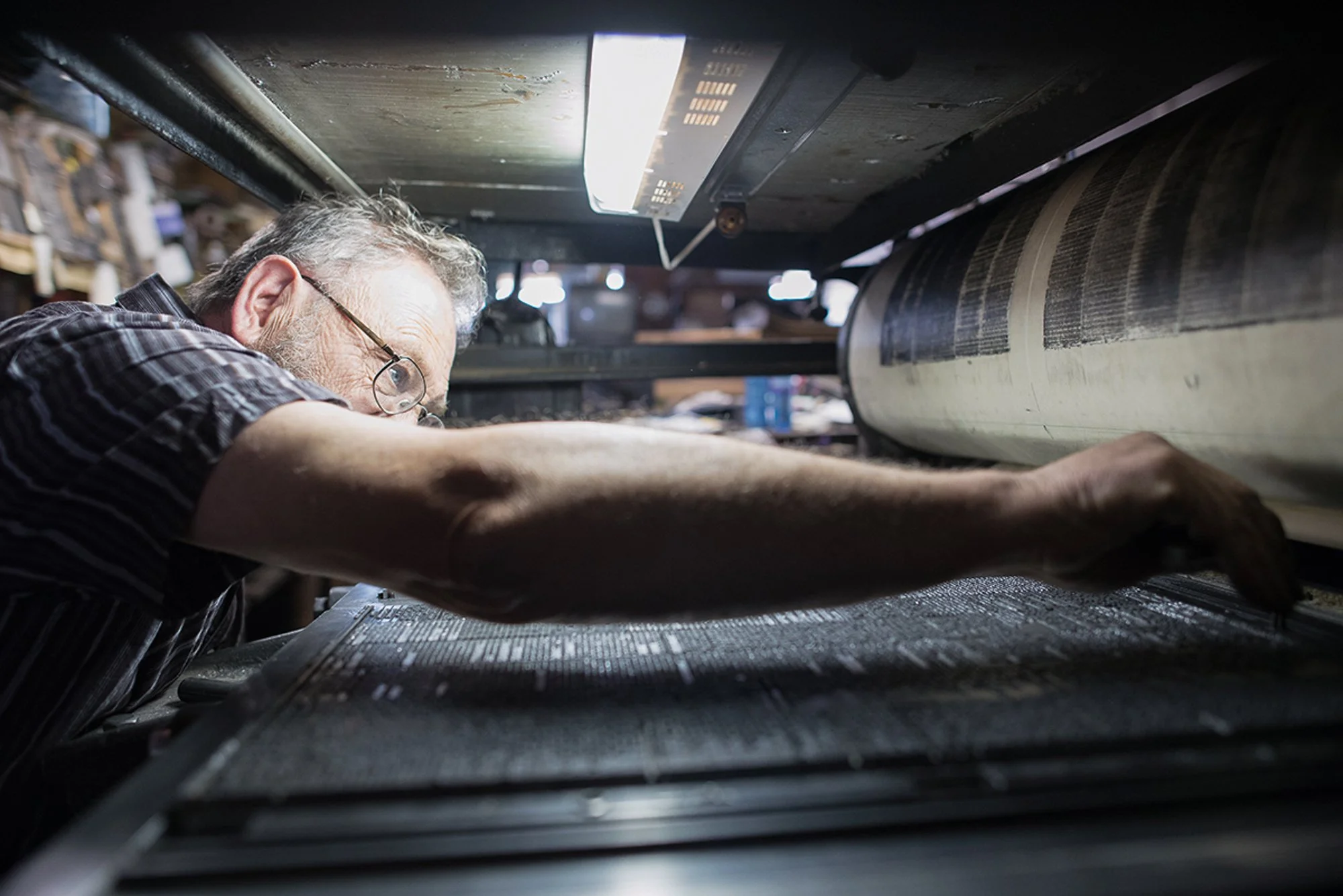 Dean Coombs working at the printing press inside the Saguache Crescent