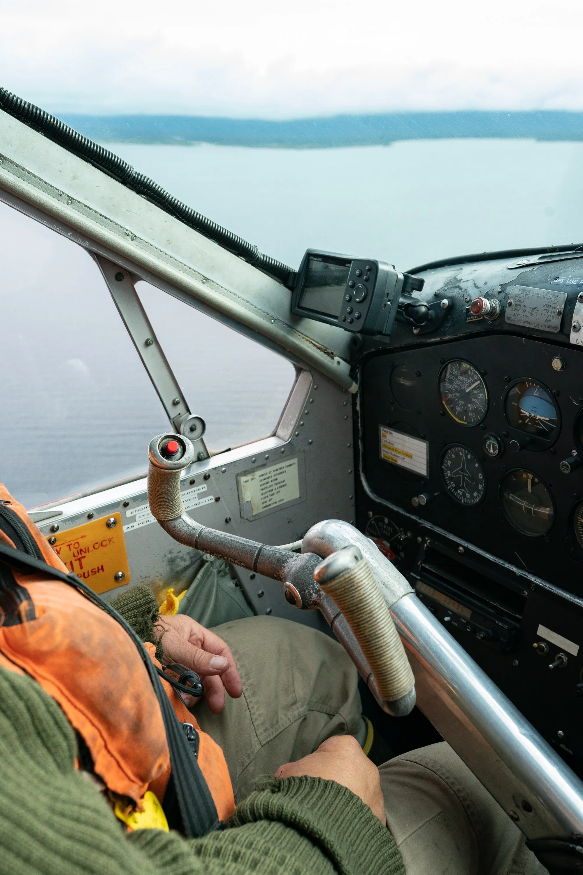 View from the cockpit of a float plane flying over an Alaskan lake