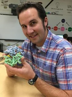 Jim Lane, holding a model of the human CFTR protein that is responsible for causing cystic fibrosis. 